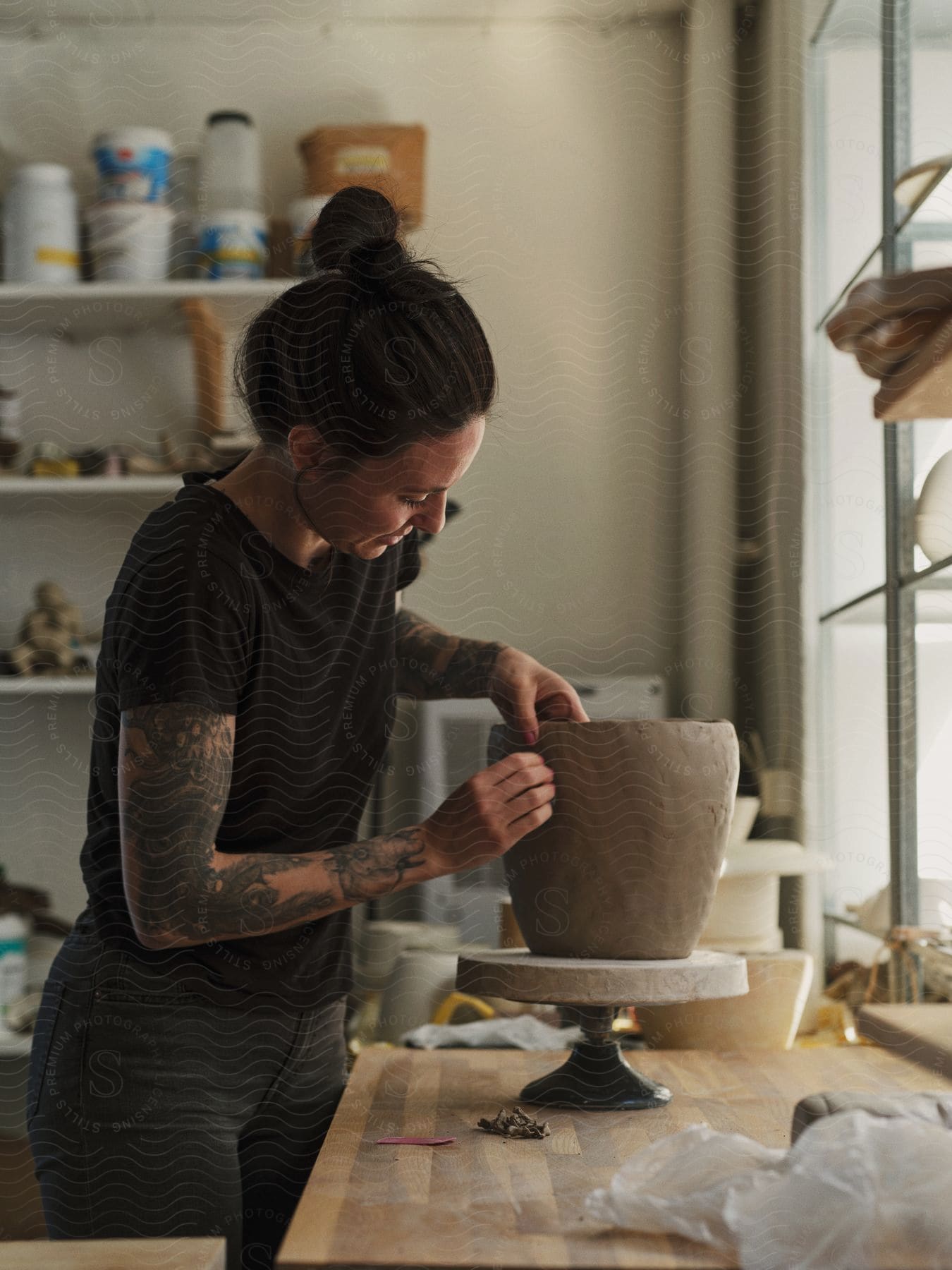 A woman working on a clay pot in an art shop