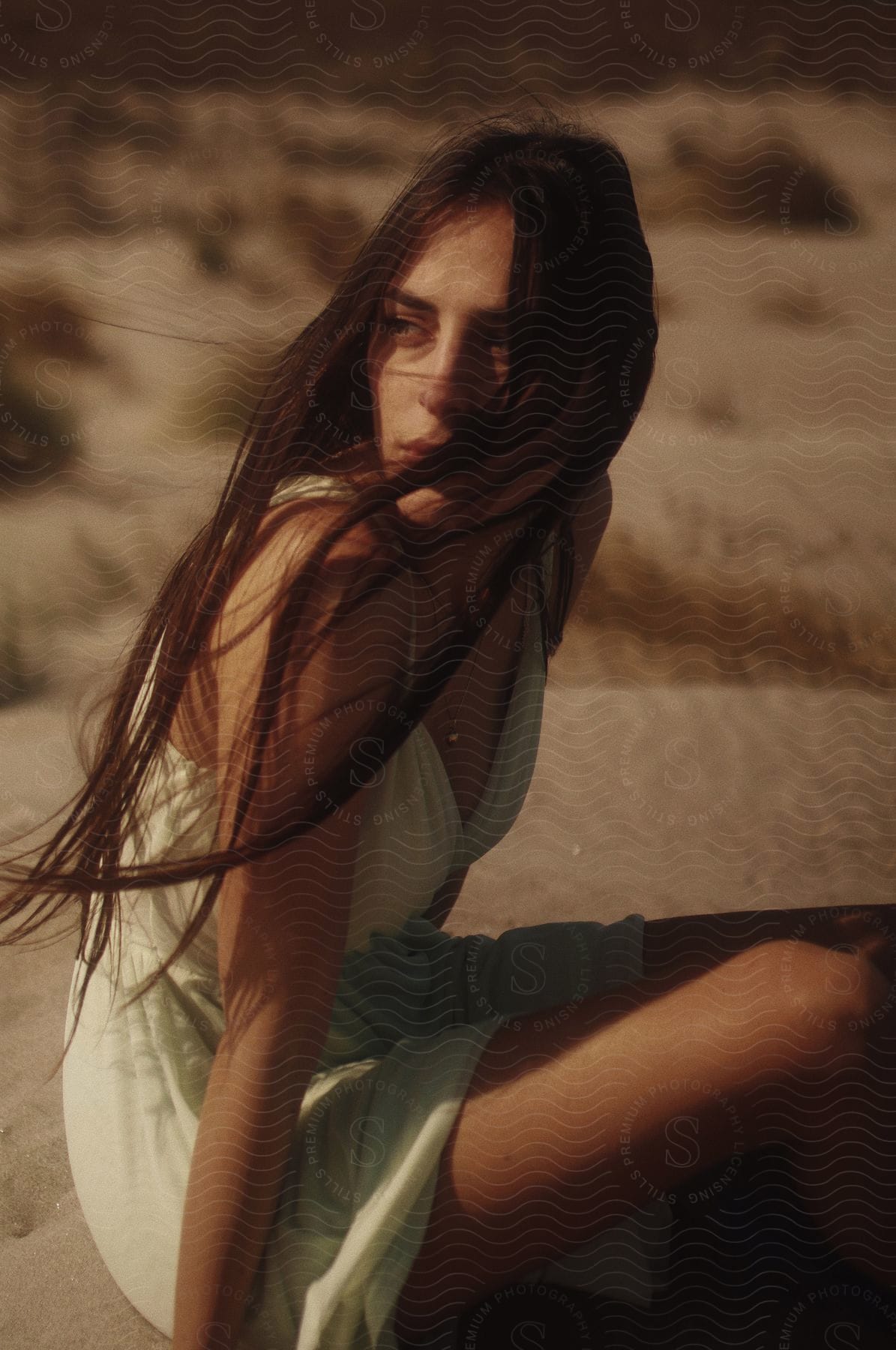 Woman sitting on sand floor in deserted landscape