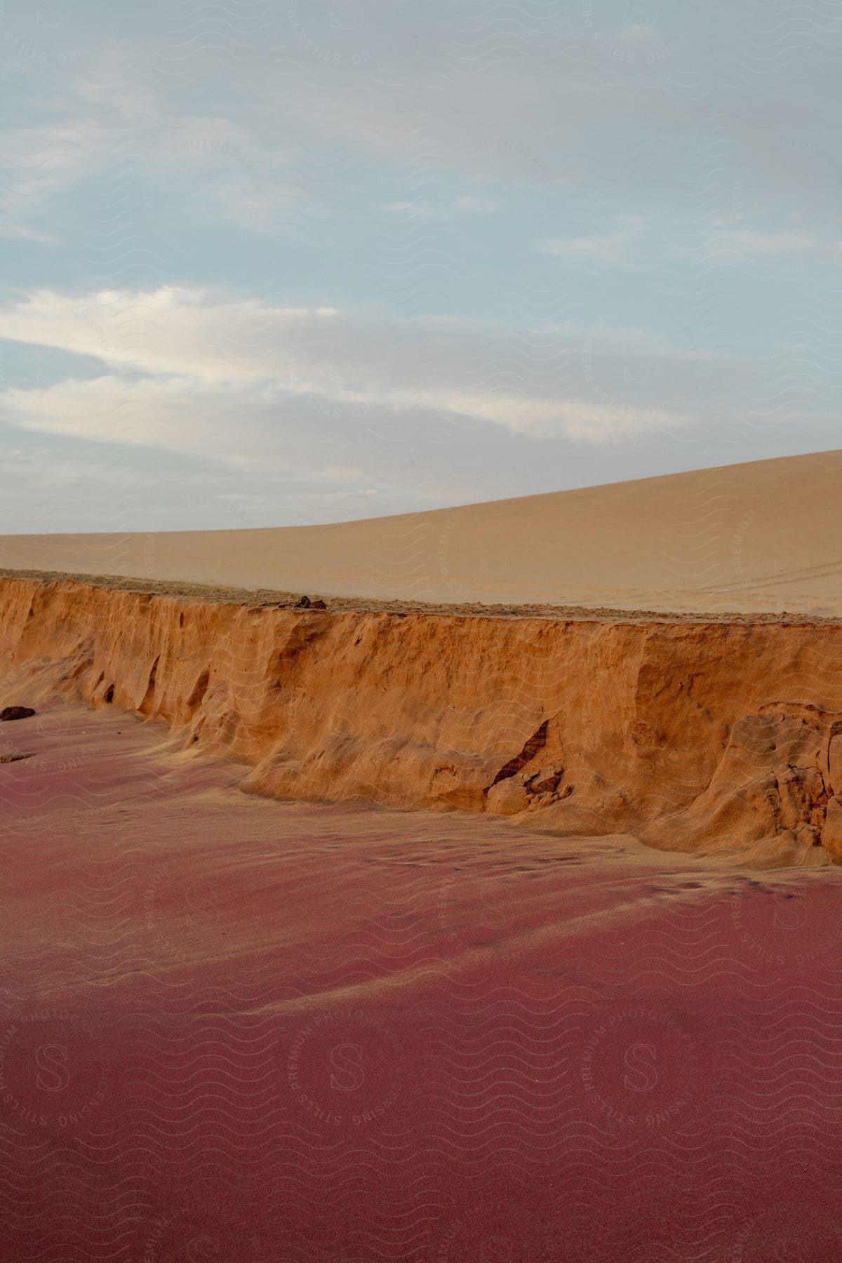 A sandy desert slope under a cloudy sky