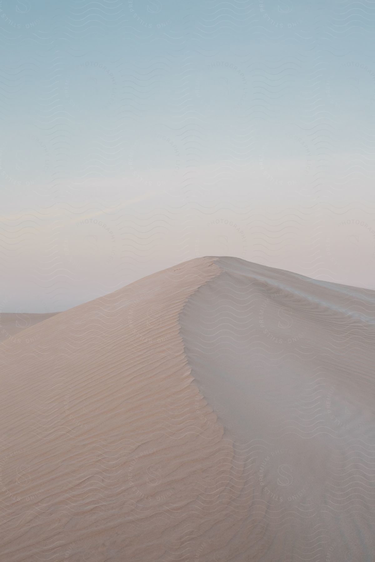 A bright day in the desert with a sand dune