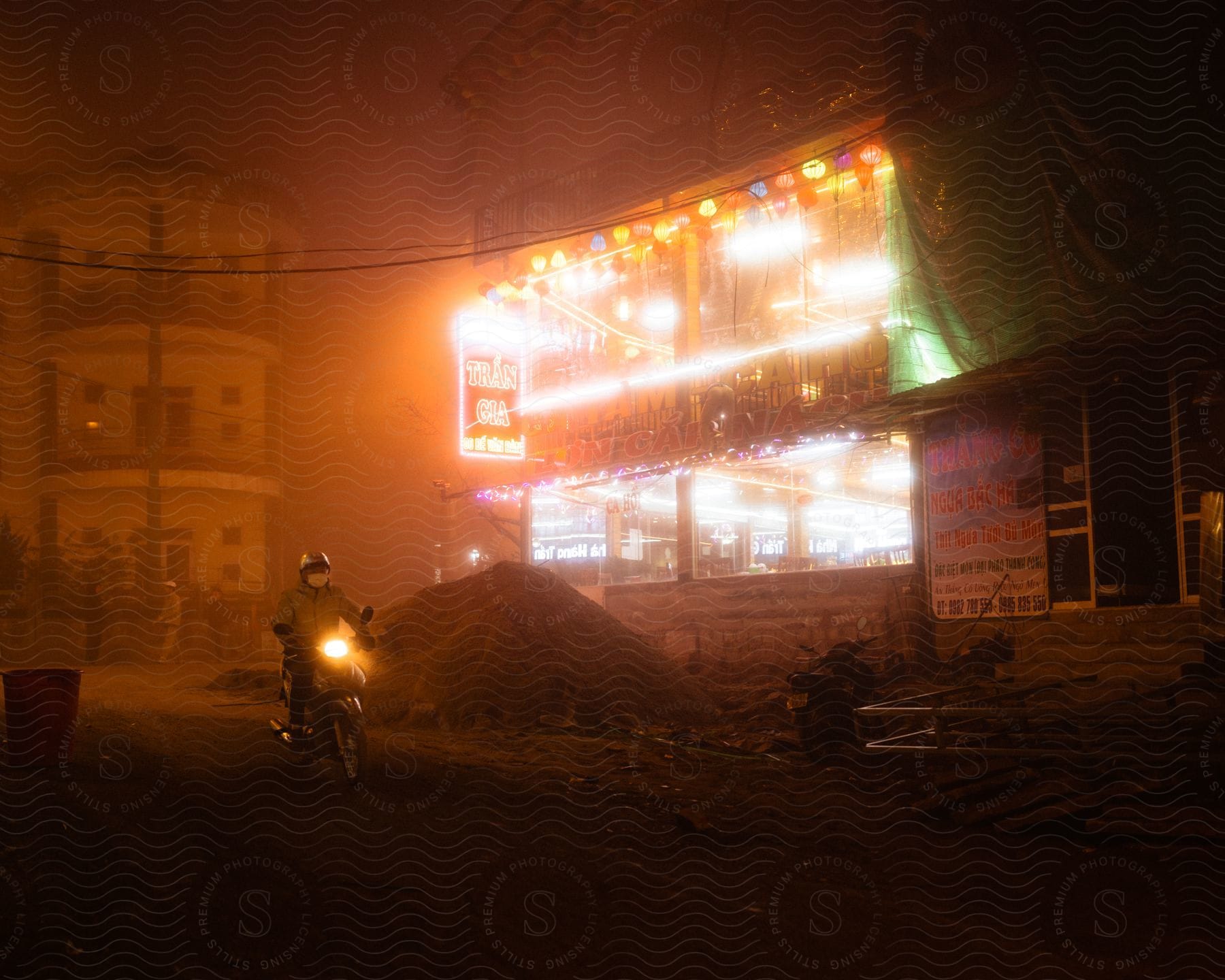 Bright Colorful Lights Of A Restaurant In The Streets Of A Town Reflecting In The Mist