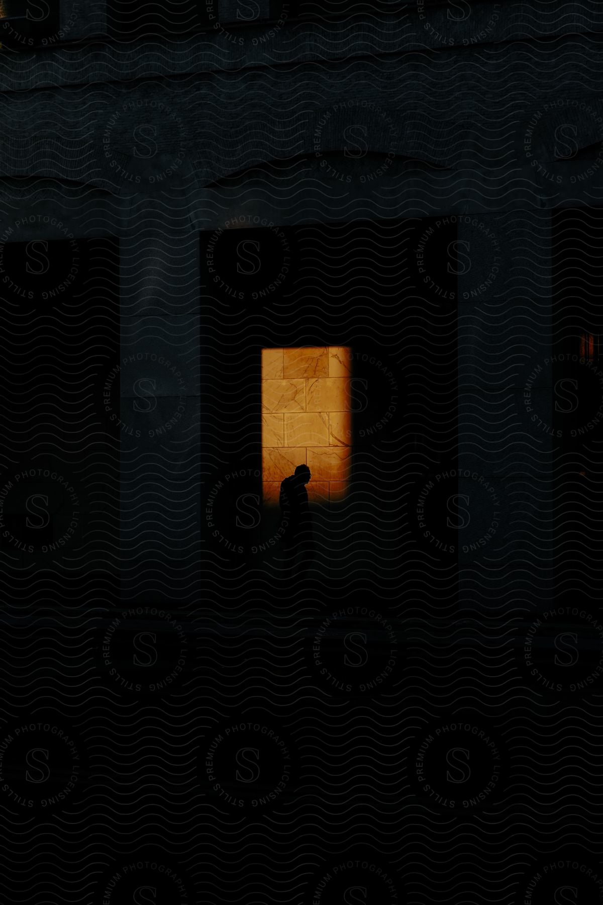 Sad silhouette of a person outside a building at night