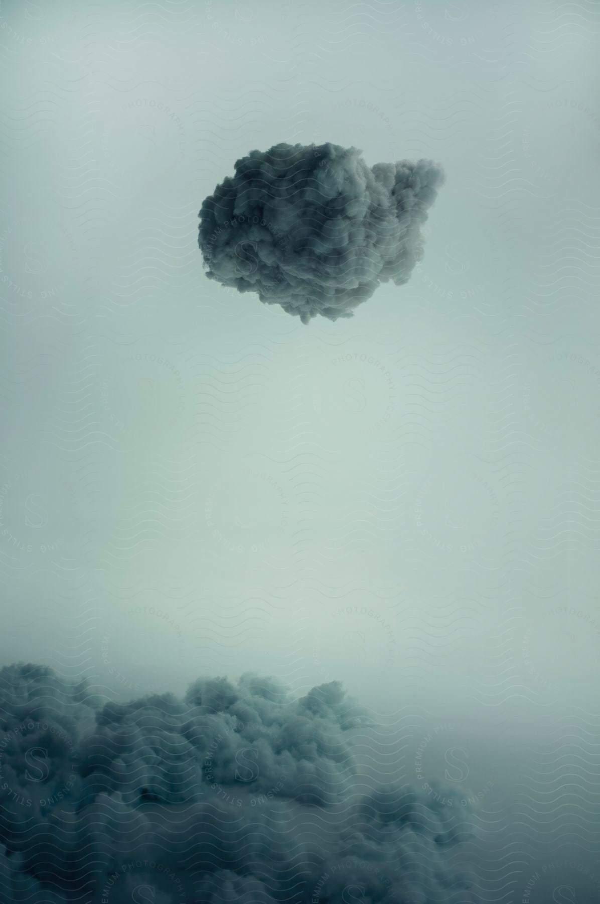 A small dark cloud hangs above a larger bank of lighter clouds in the sky