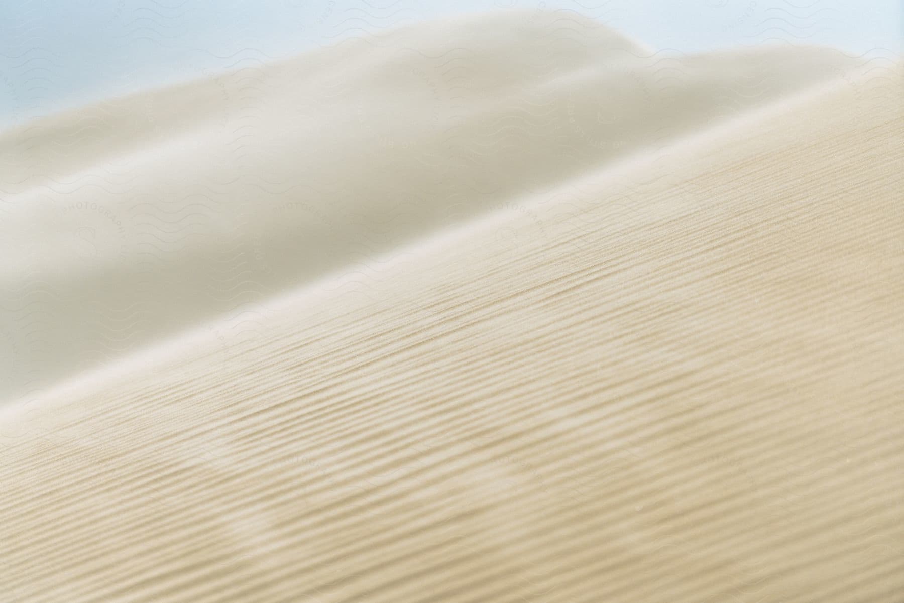 A barren desert landscape with sand dunes under a cloudy sky