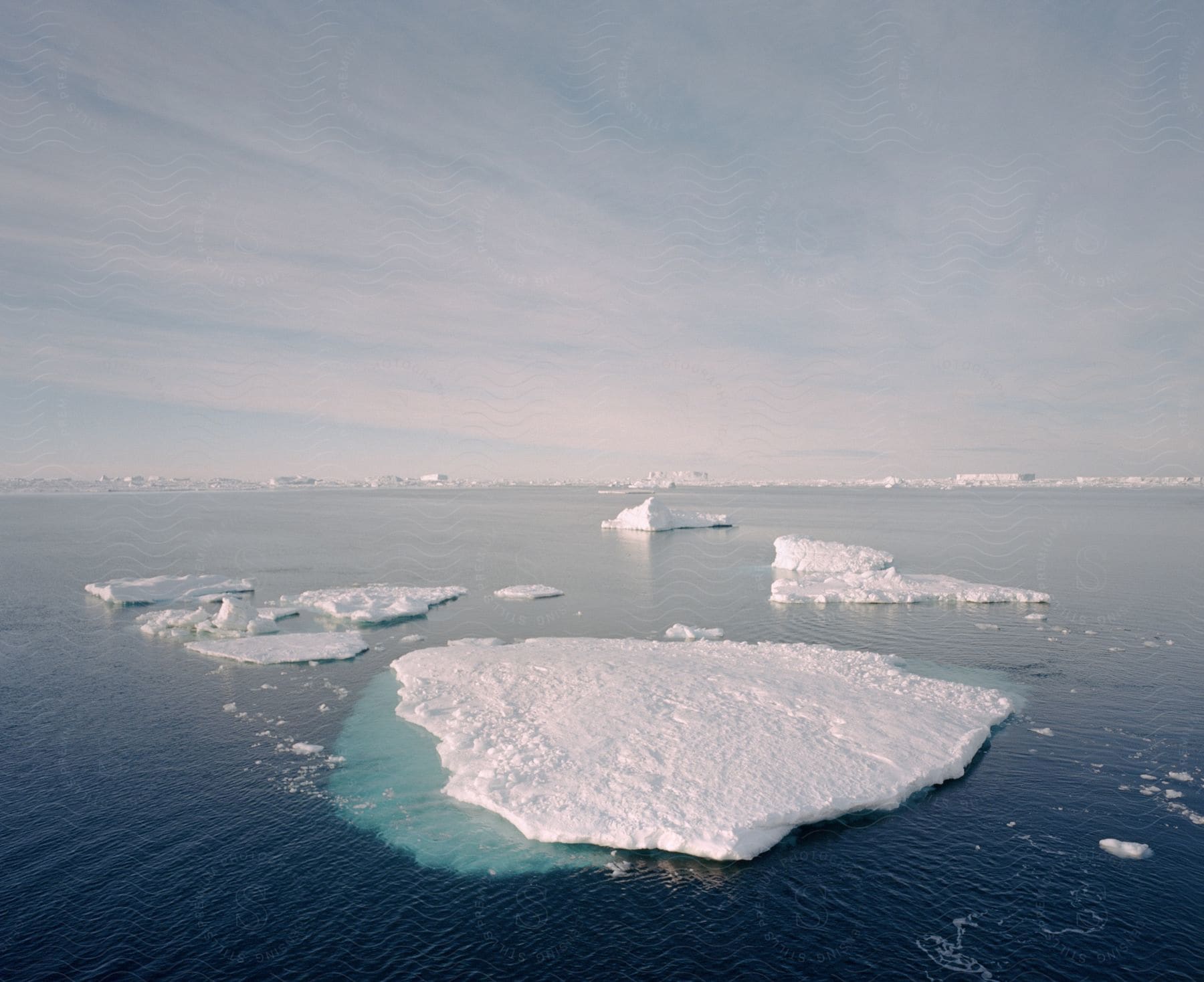 Small ice caps floating on water in an exterior view during the day