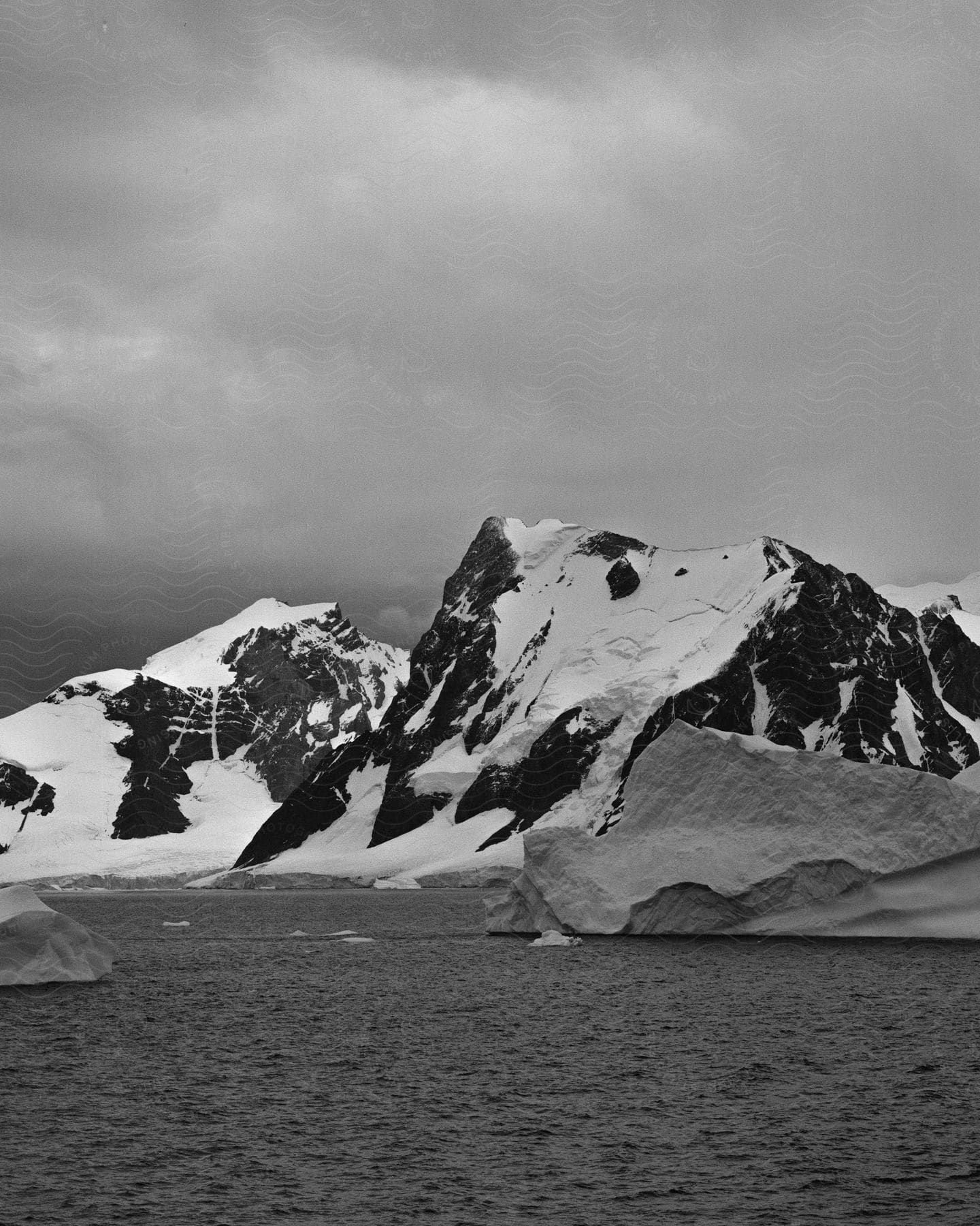 A black and white snowy mountain is visible against the ocean