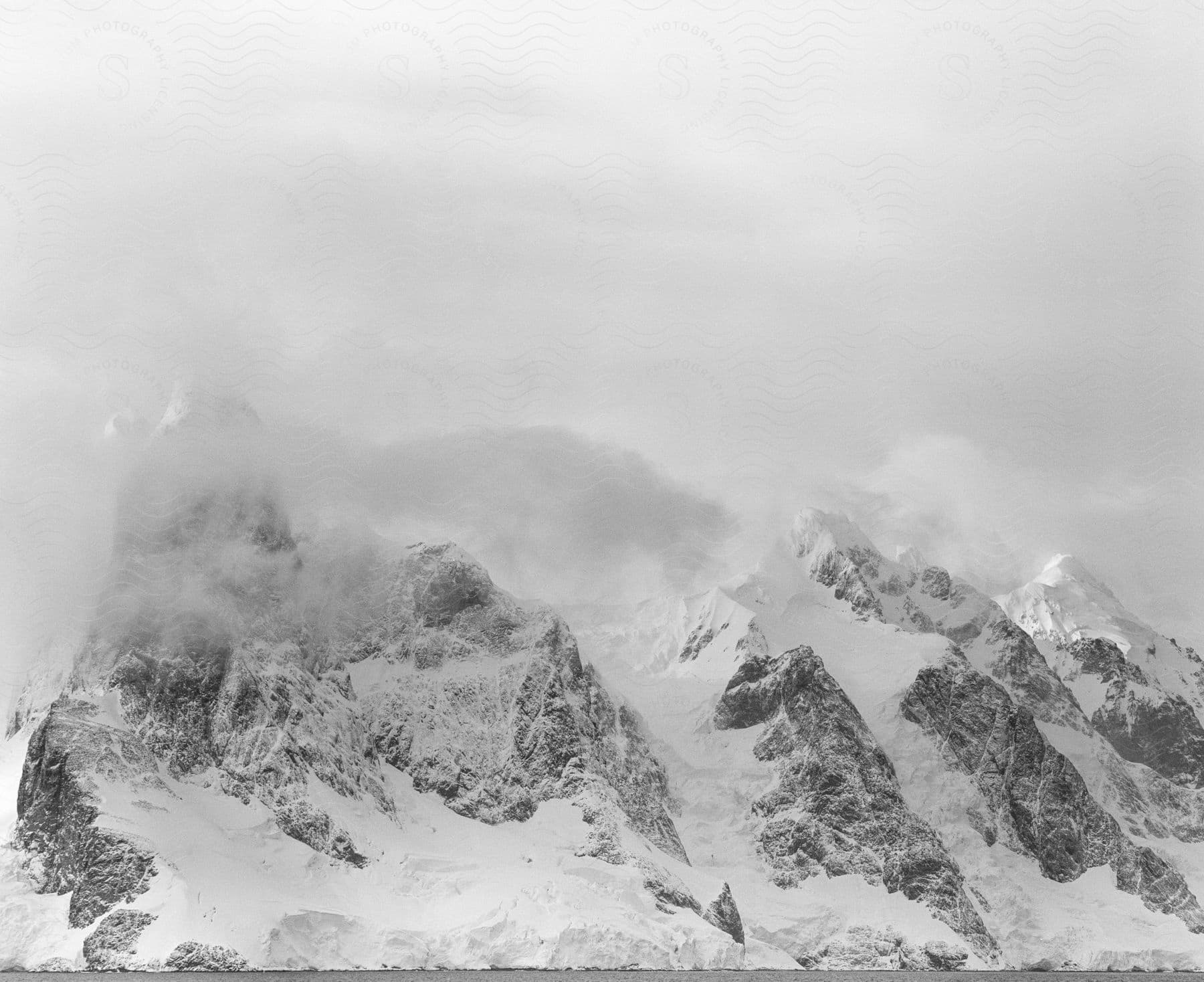 Snowy mountain ridge surrounded by clouds in a natural landscape