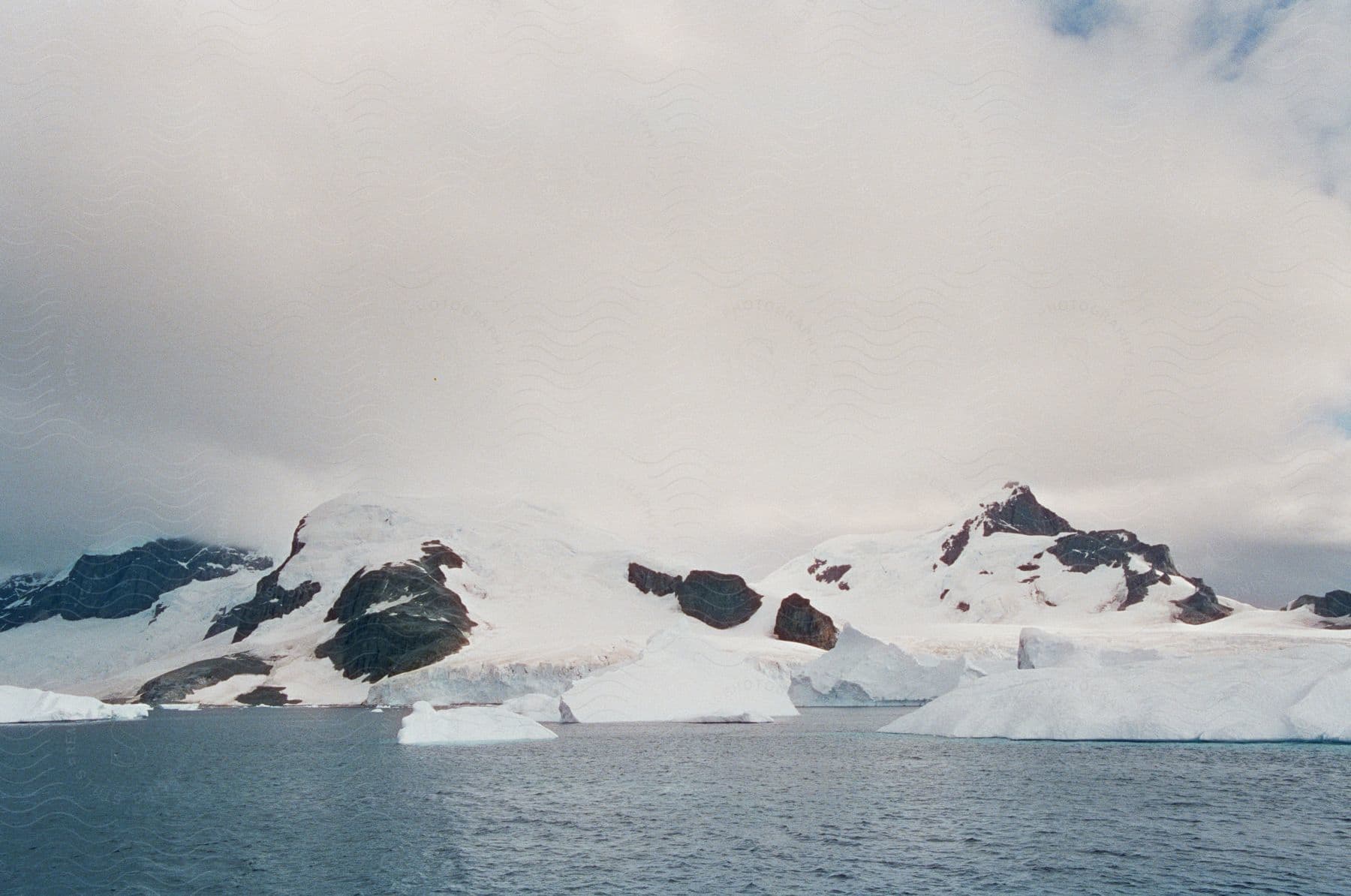 A serene snowy landscape with mountains ice and a glacier