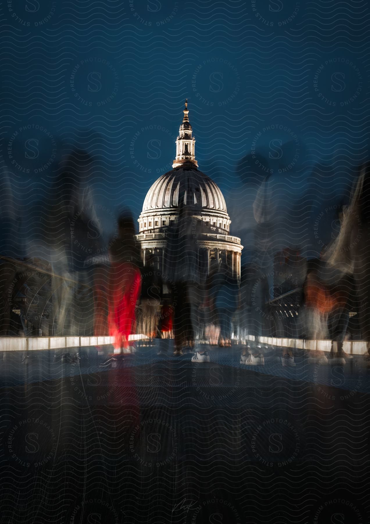 Blurred photo of people on a walkway with an old architecture building in the background