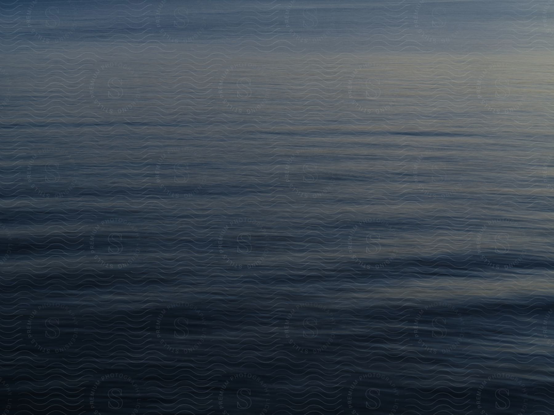 A dark blue body of water with a few ripples