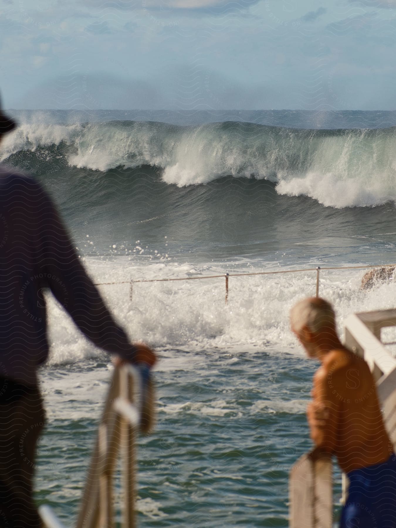 A giant wave approaches a beach while two men observe