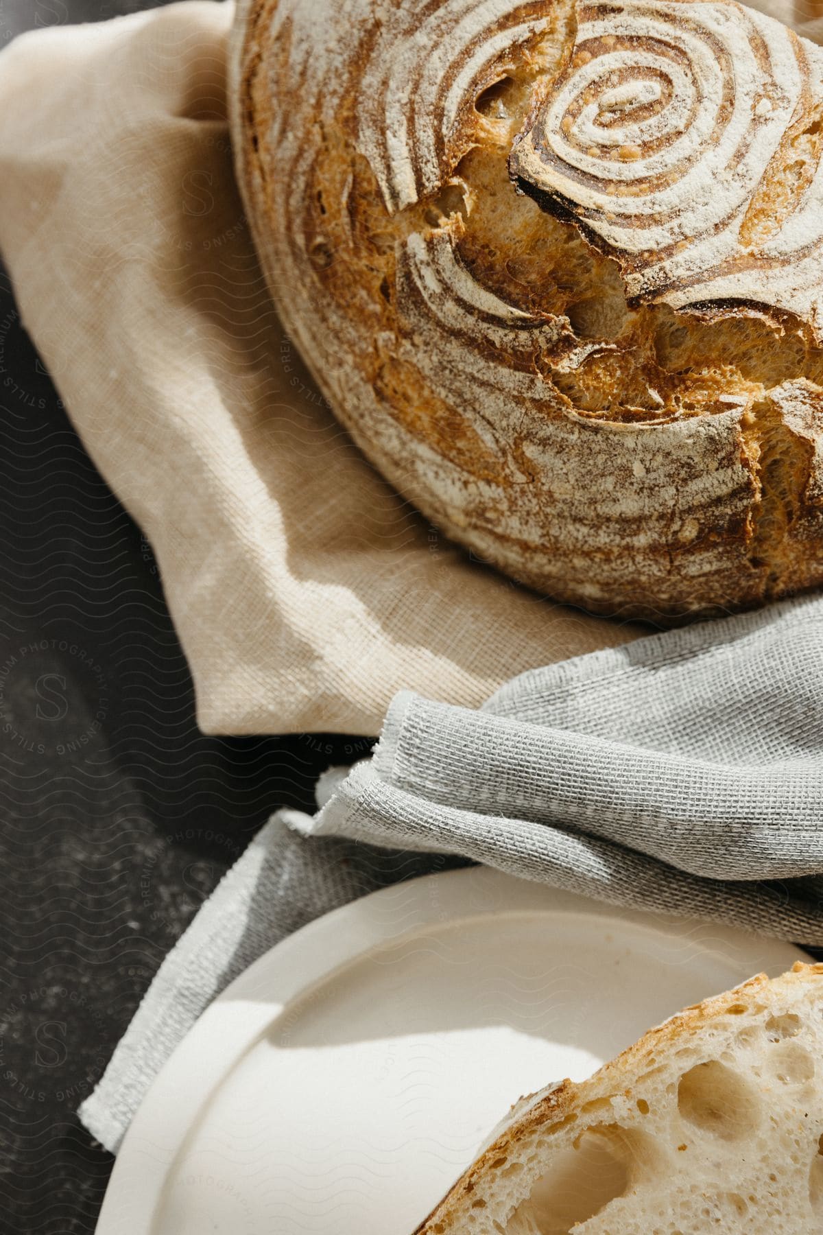 Freshly baked bread with swirls cut in the top placed on a plate