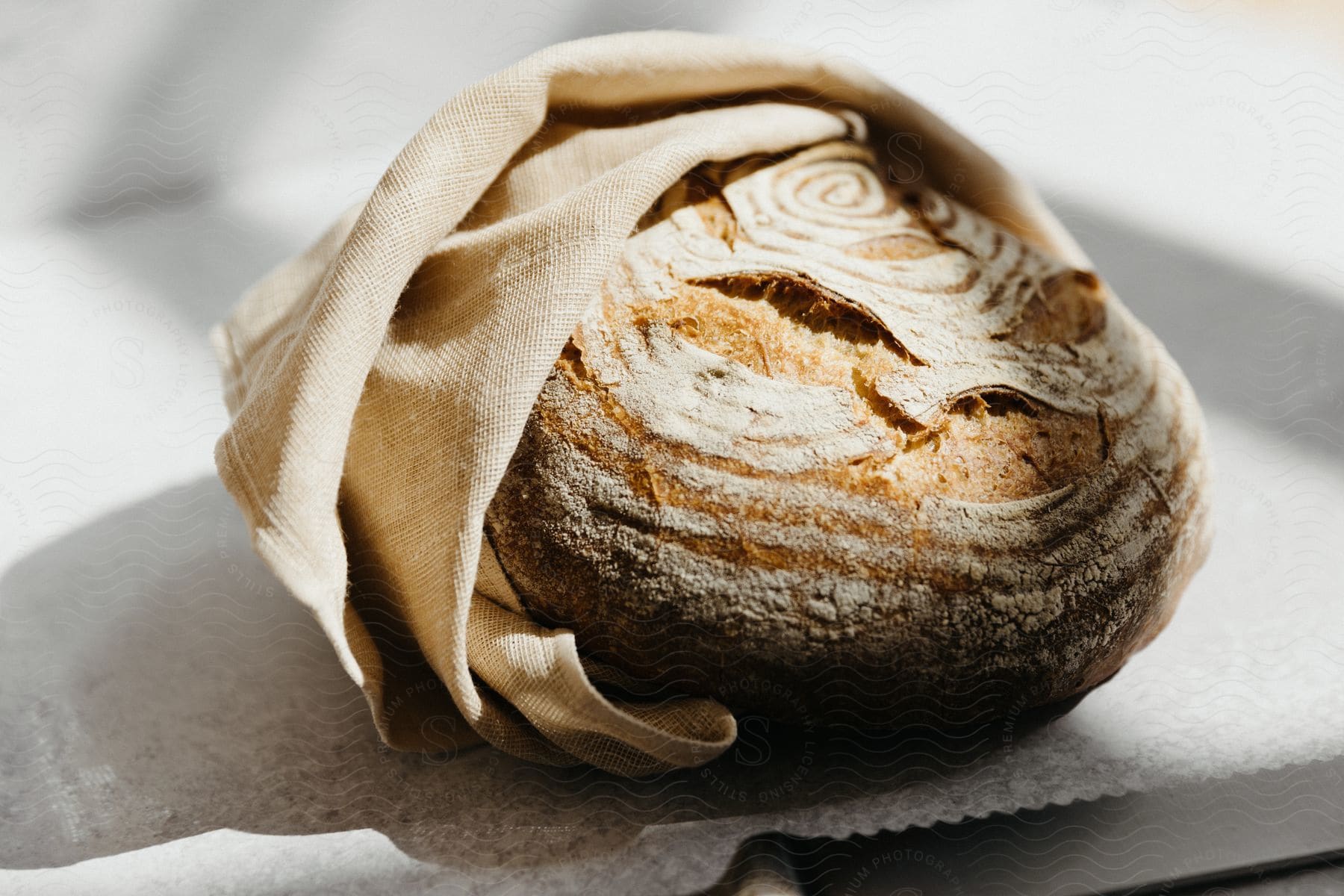 A fresh baked bread loaf wrapped in a napkin