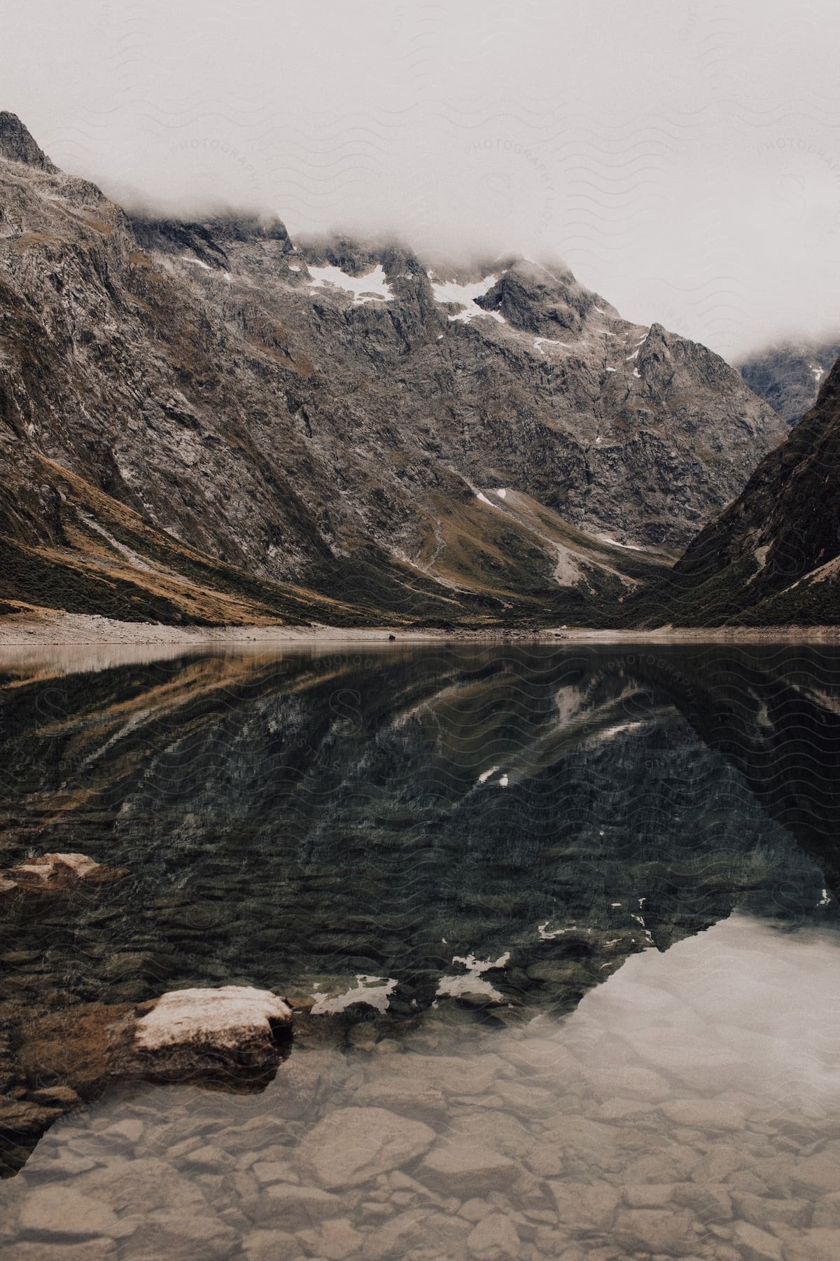 Snowtopped mountain reflected in water of a stream