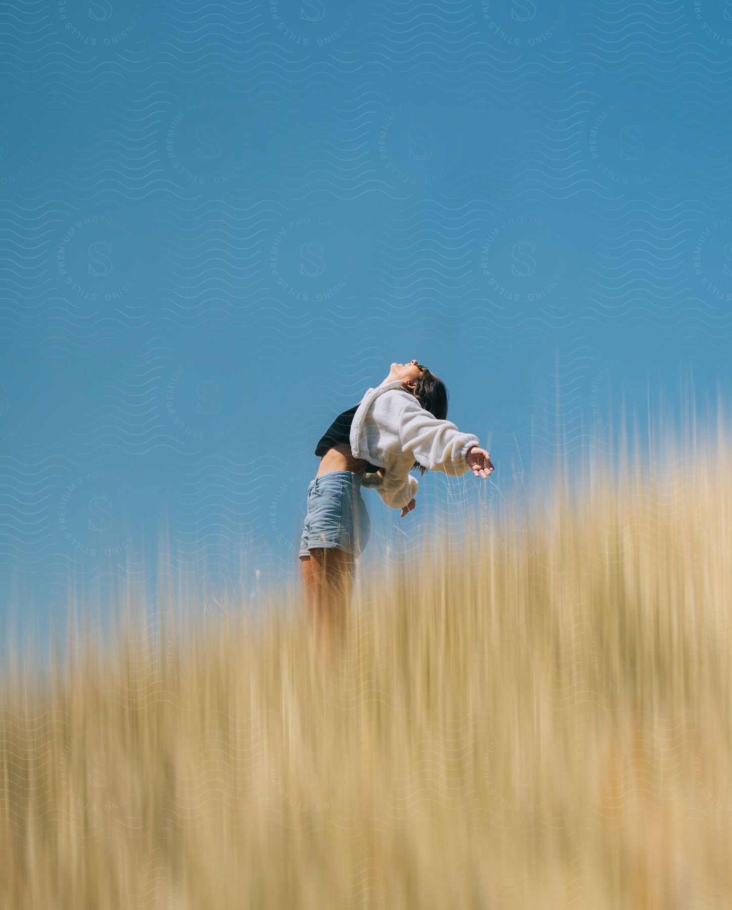 Stock photo of a woman standing in a sunny field