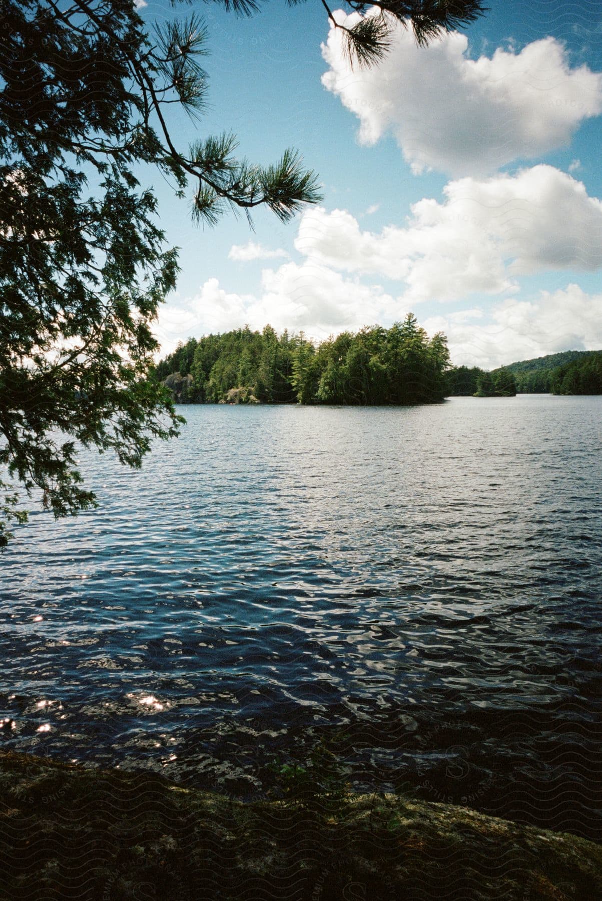 A lake with clear water and small islands with trees in the adirondack mountains