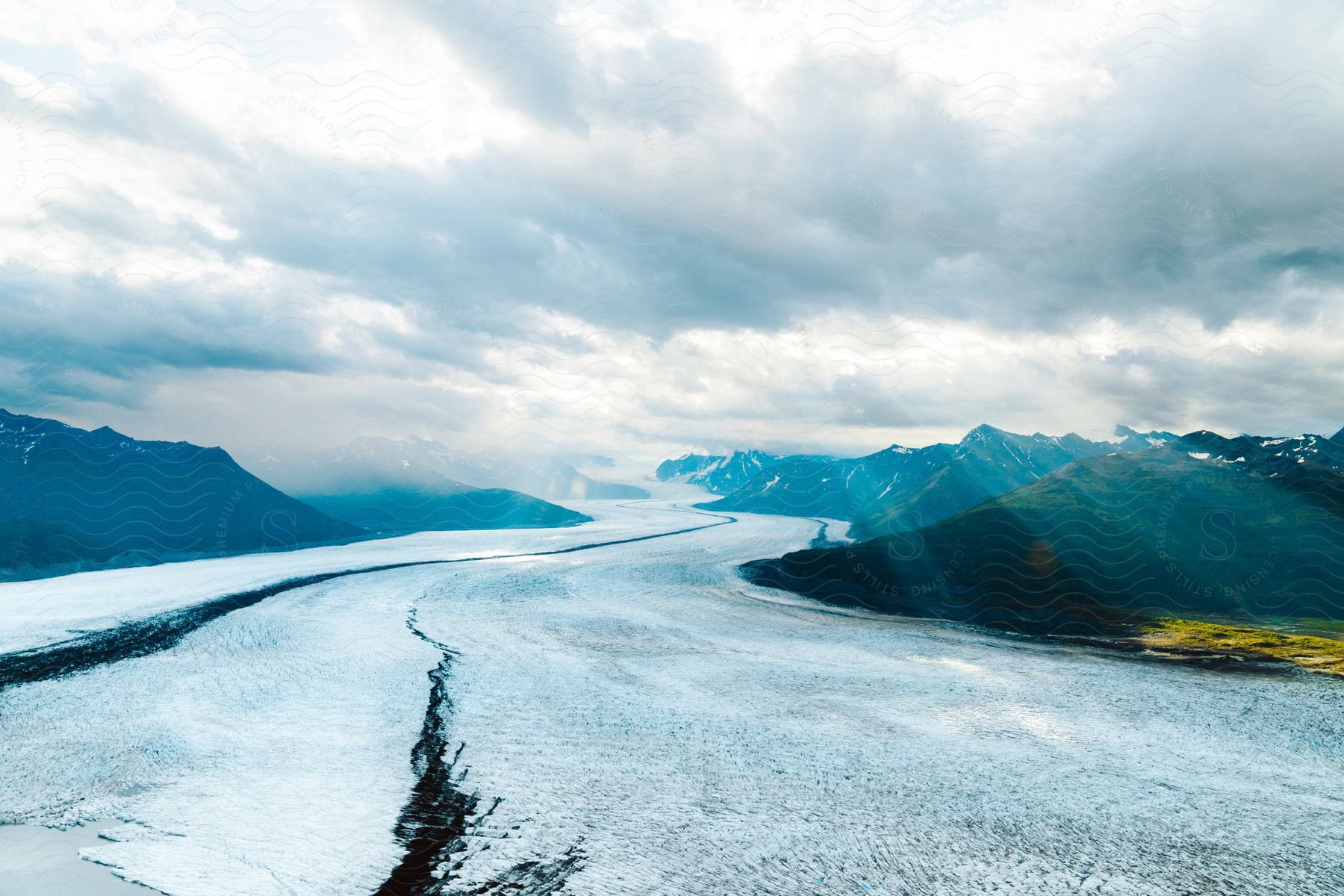 A natural landscape with mountains snow and a cloudy sky in alaska