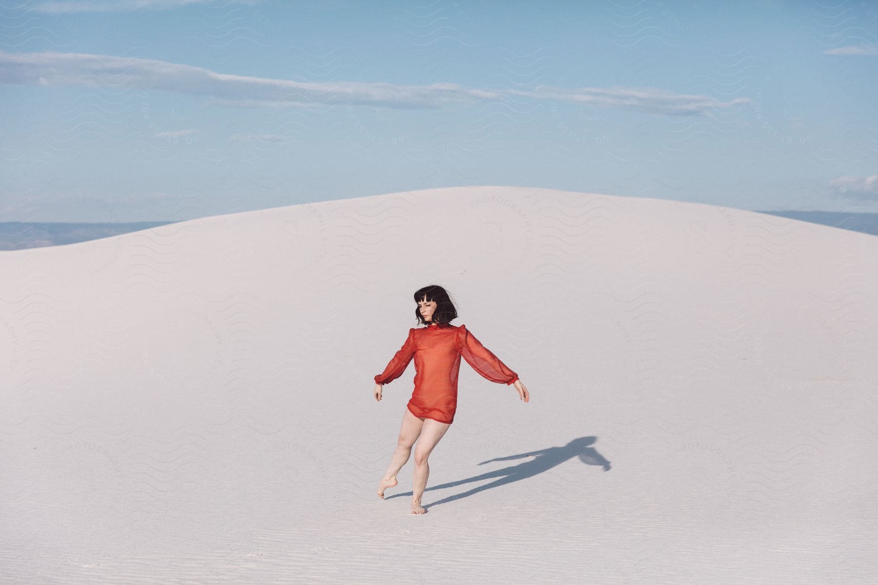 A woman standing in sand on a sunny day in new mexicos white sands