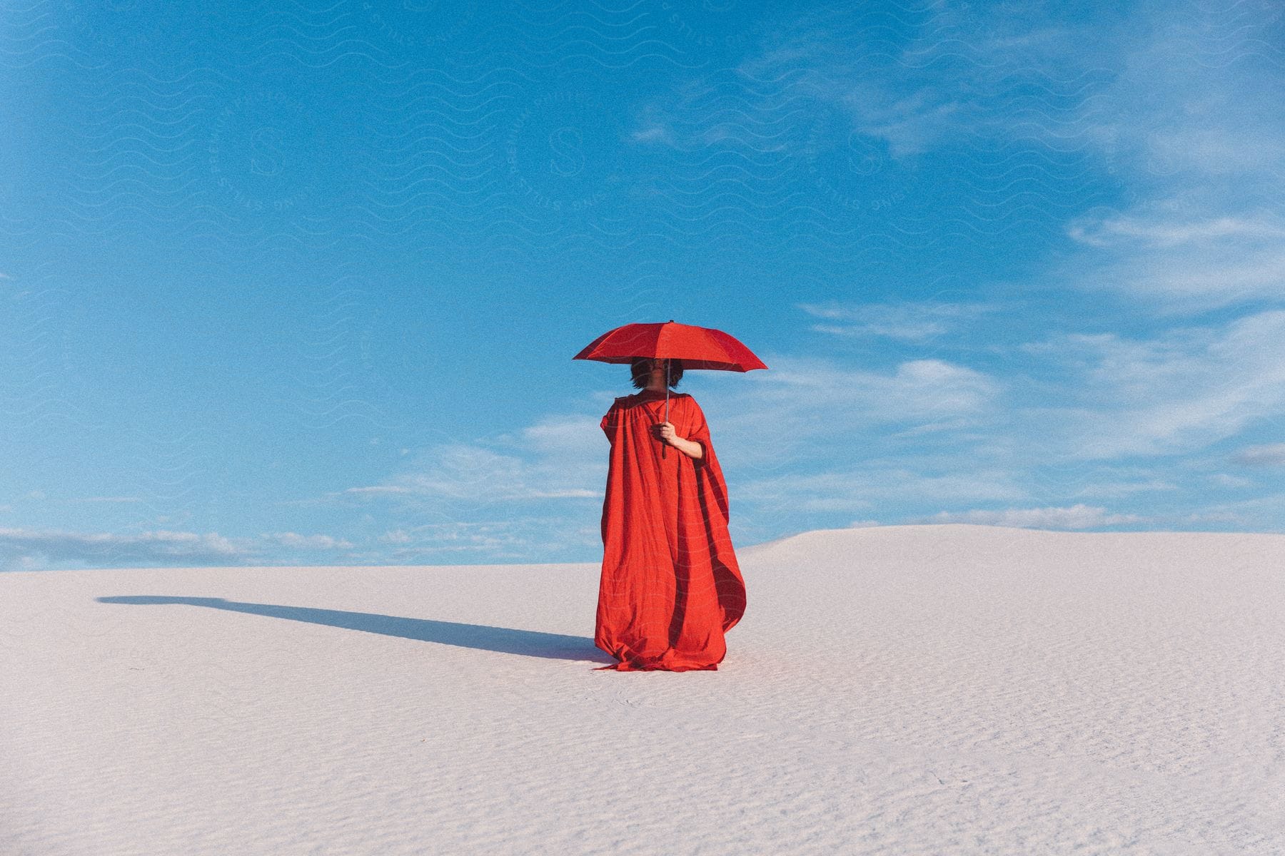 A woman in beachwear standing under a sky with azure clouds