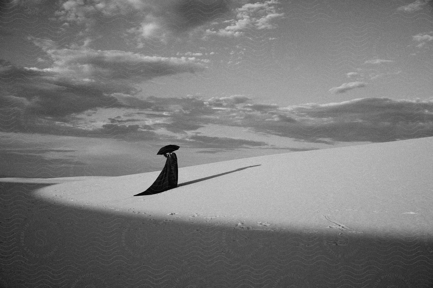 Woman With Black Dress Holds Black Umbrella In The Desert