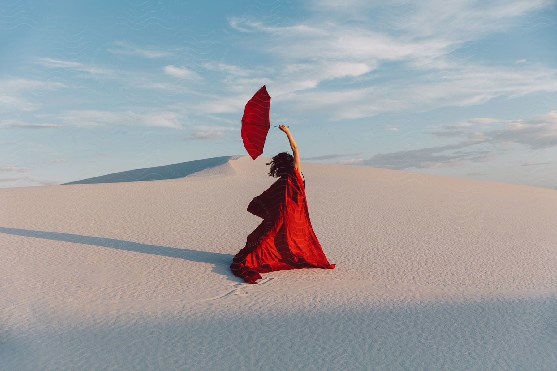 A woman holding an umbrella in the desert