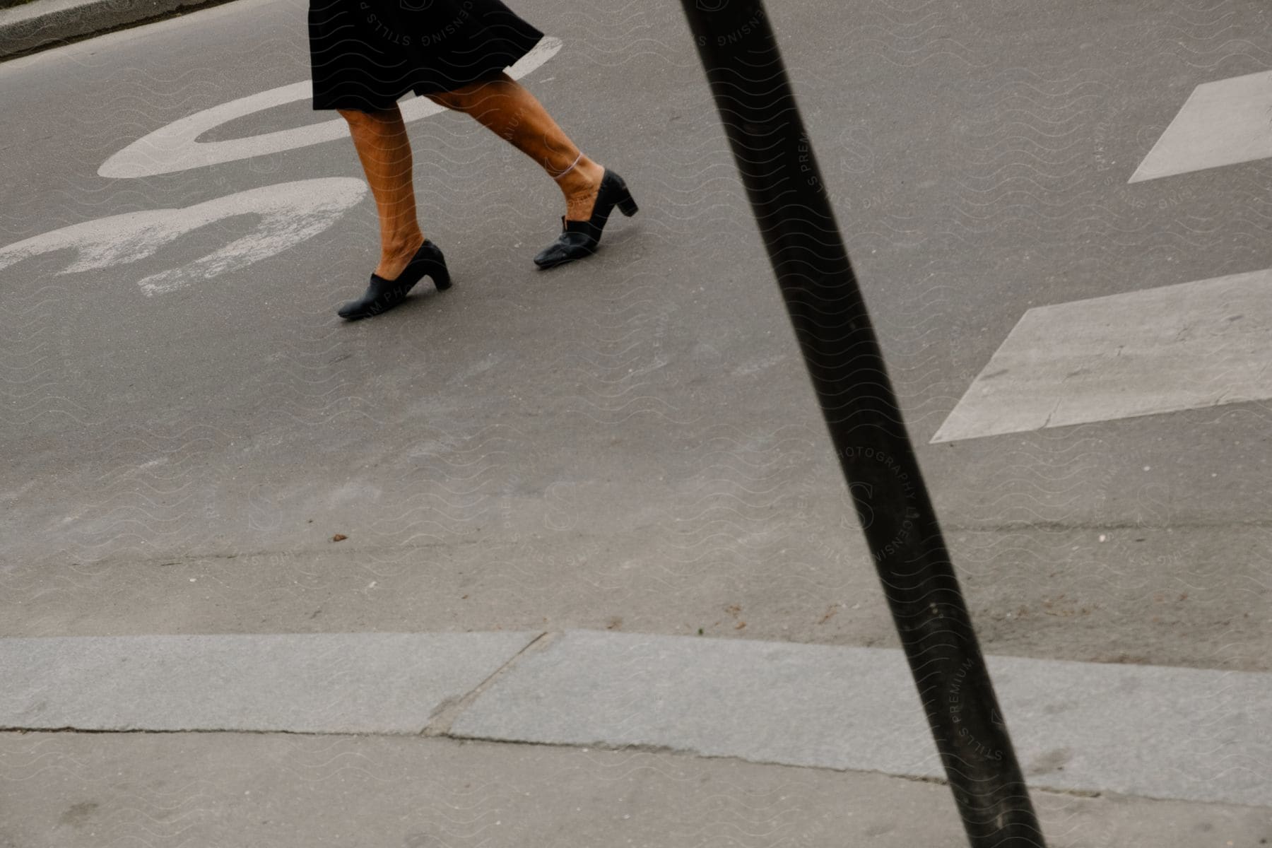 A woman walking away from a crosswalk in paris