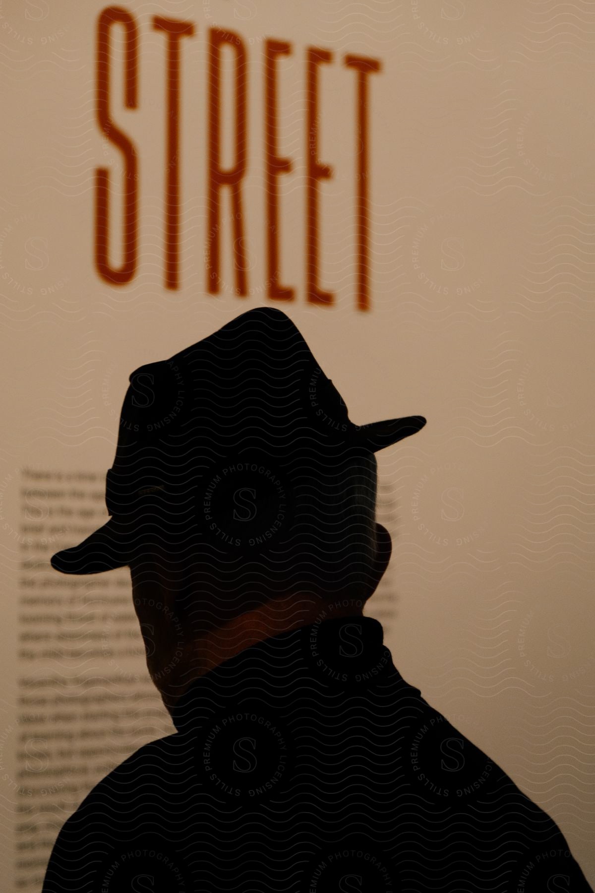 A mans silhouette in front of a poster with text