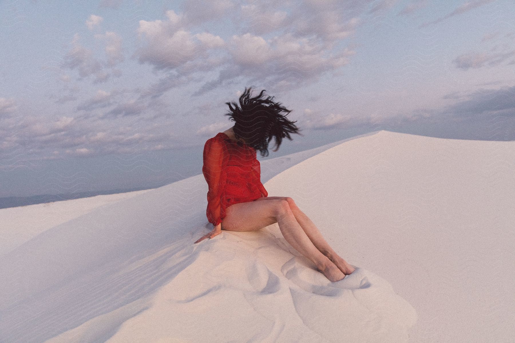 A Woman Sitting In The Sand On A Sunny Day At White Sands New Mexico