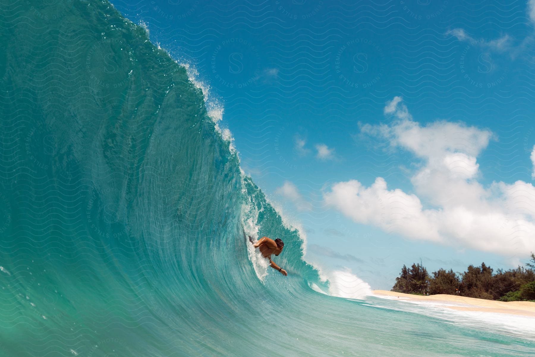 A man swimming inside a wave as it begins to curl into a pipe