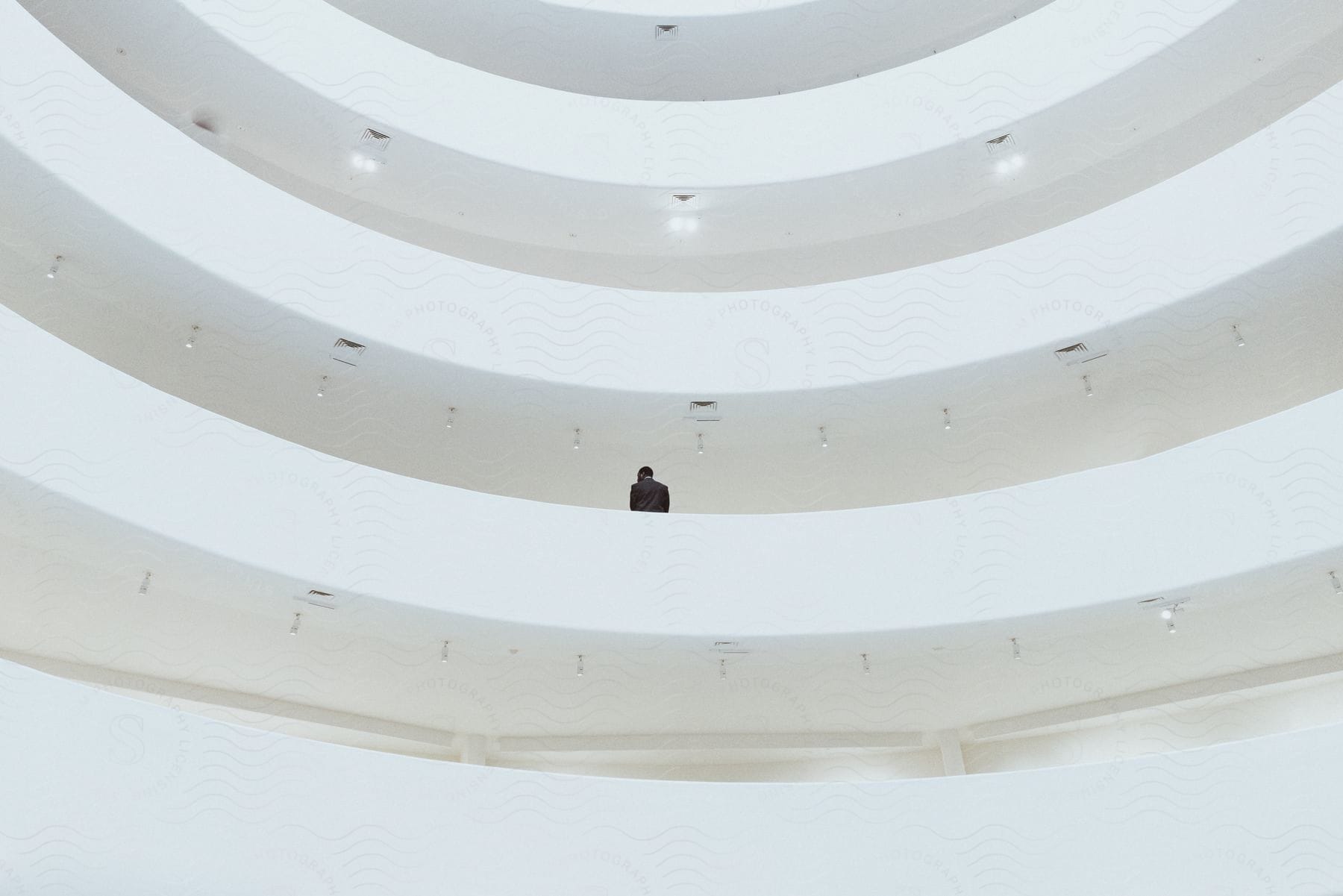 Black man wearing a suit standing inside the solomon r guggenheim museum