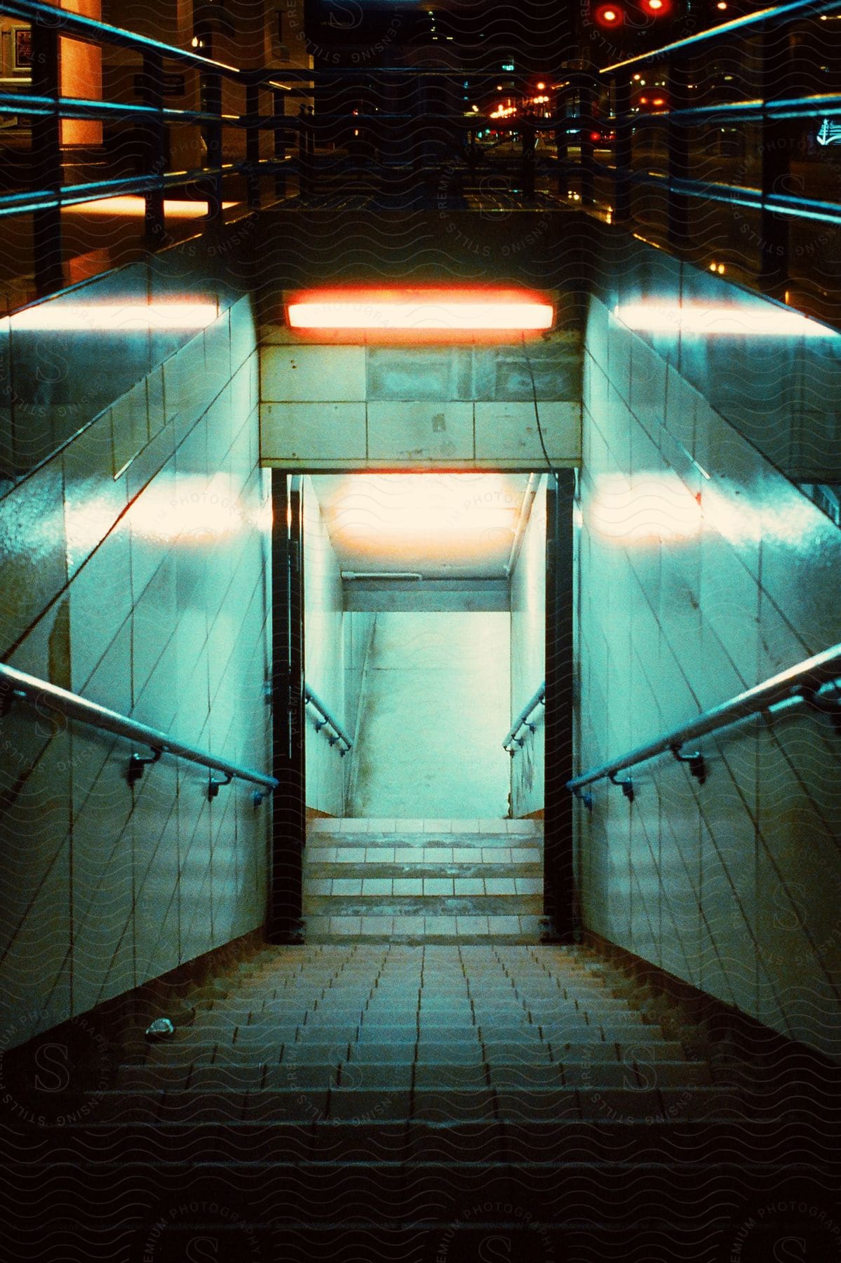 A staircase leading down to the subway system in a metropolis at night