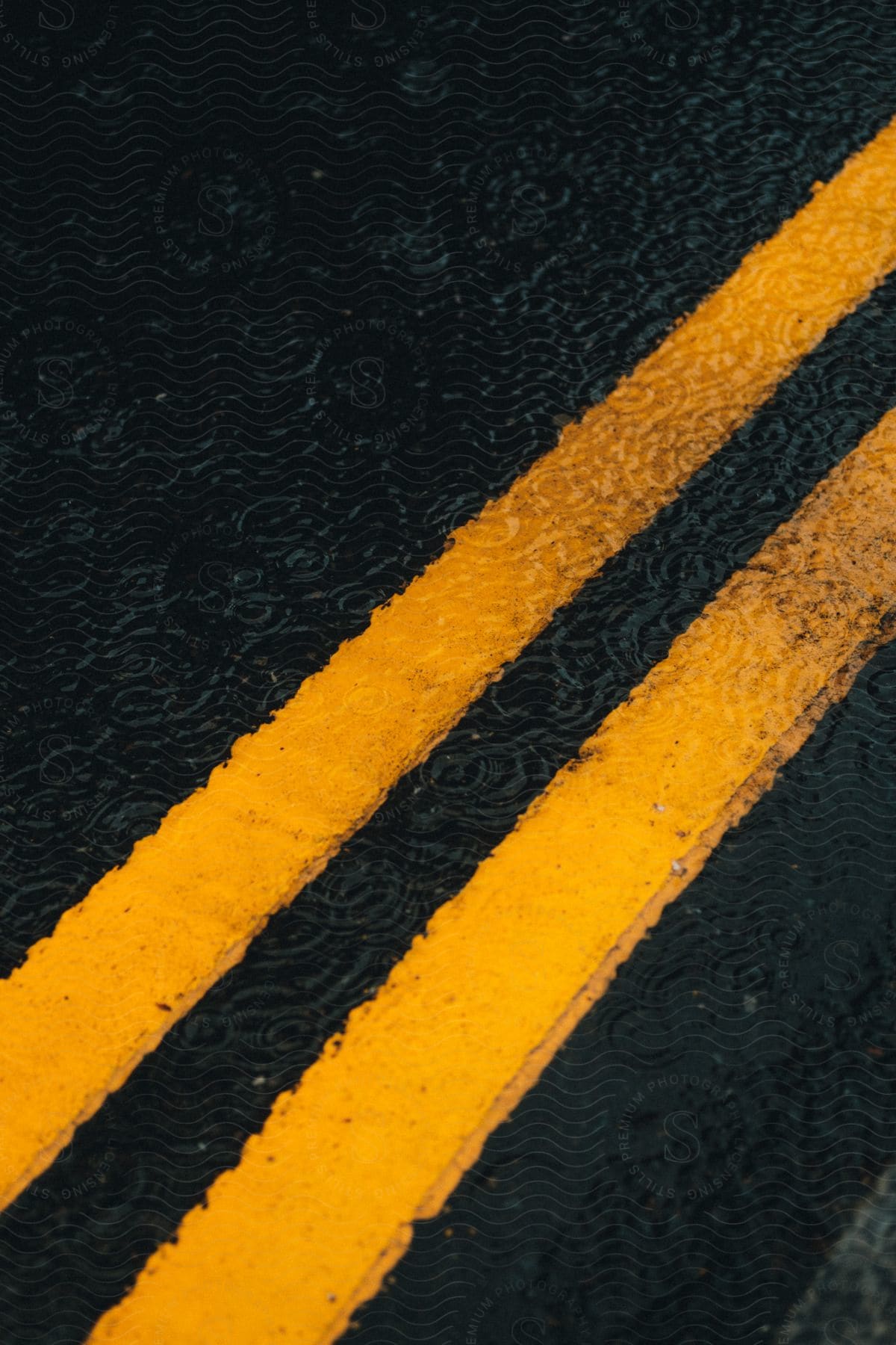 Water drops falling on a puddle over the road surface