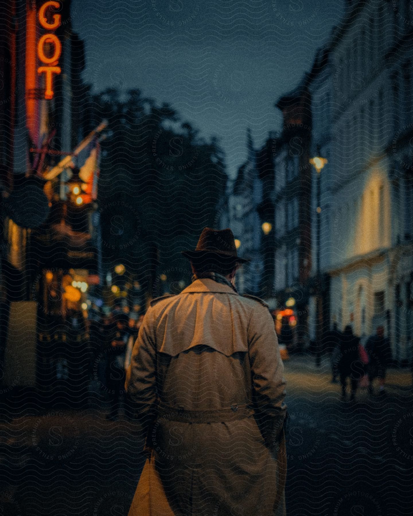 A confident man in a stylish hat walks with hands in pockets in an open space