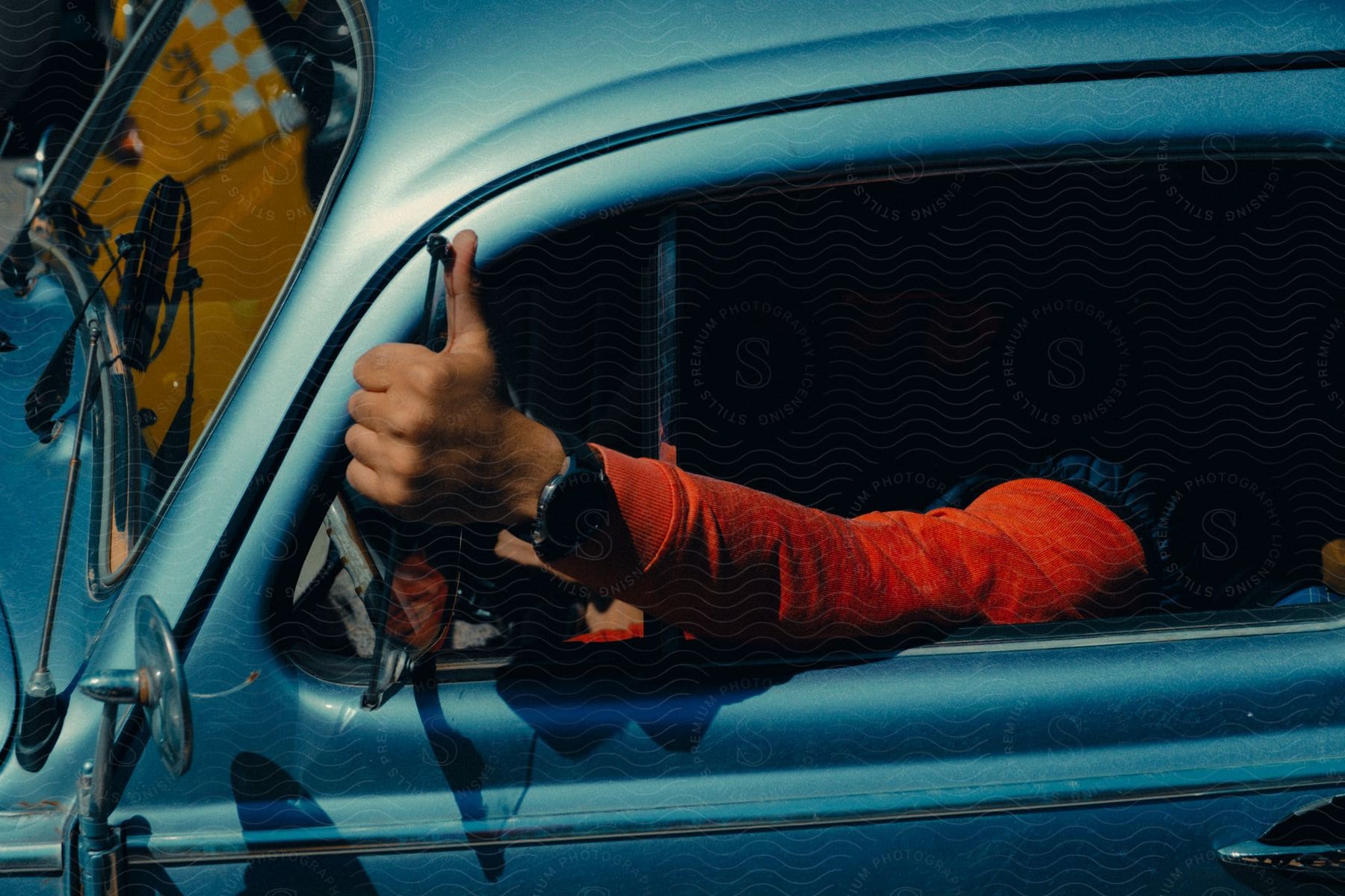 Man driving a car with obscured face seen from outside the window