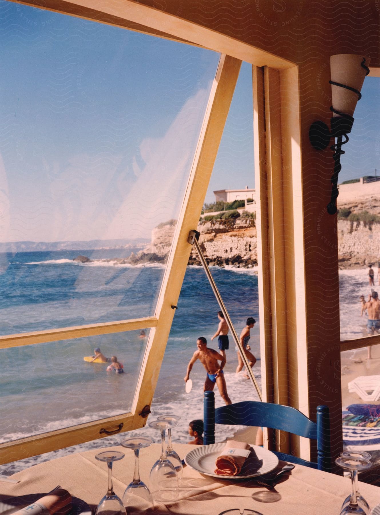 People watching themselves at a beach from the window of a restaurant