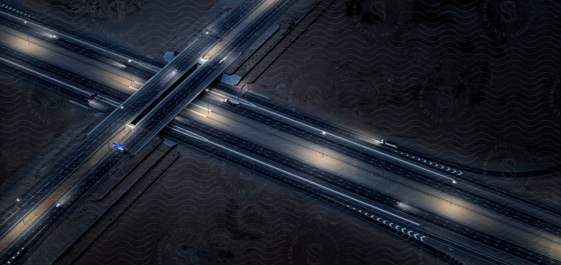 Aerial view of a crossing of highways with various vehicles at night in dubai