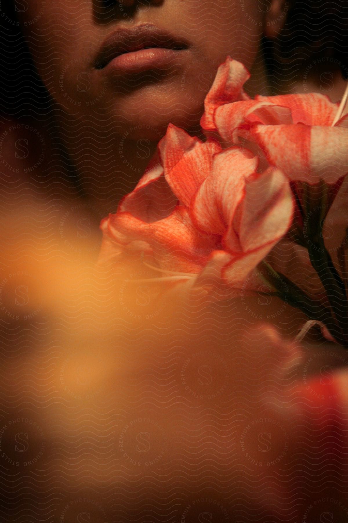 A woman holding a flower indoors at night time