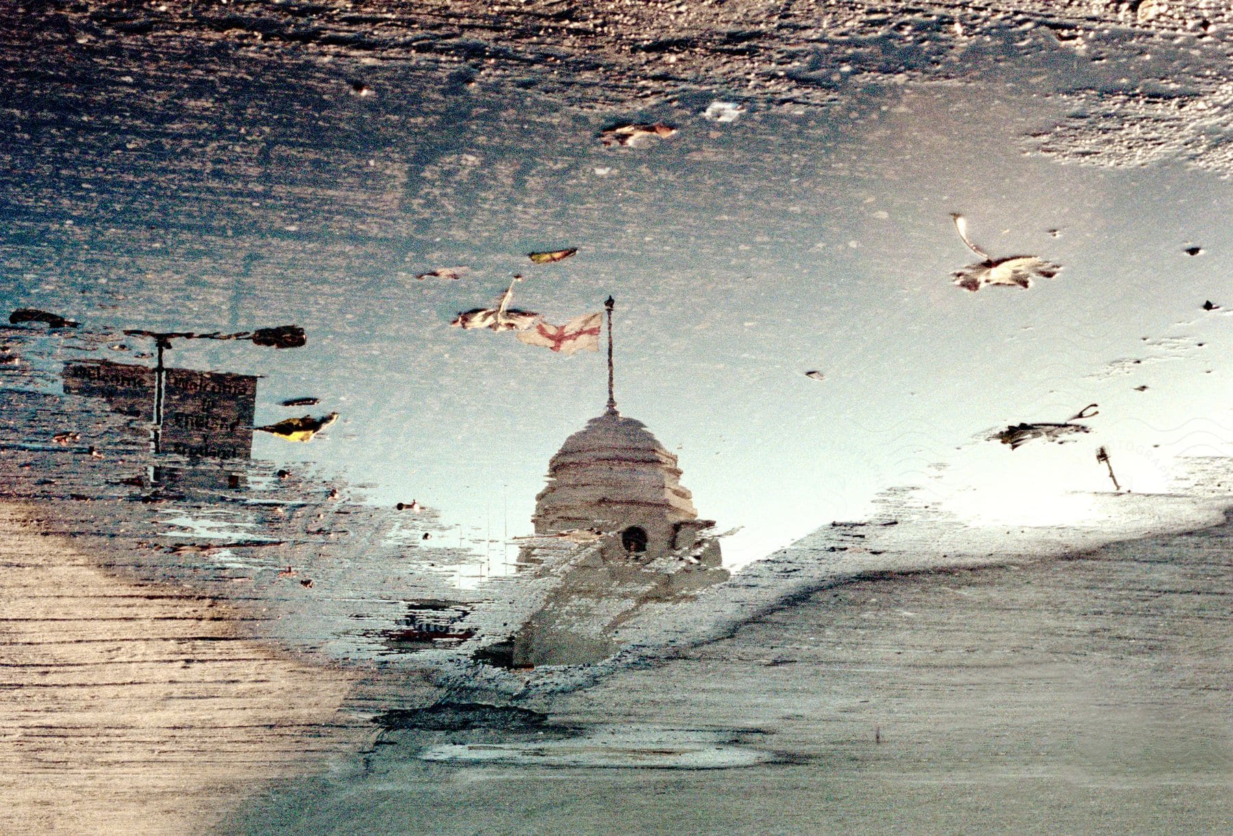 A painting of a white tower with a flag in a blurred landscape