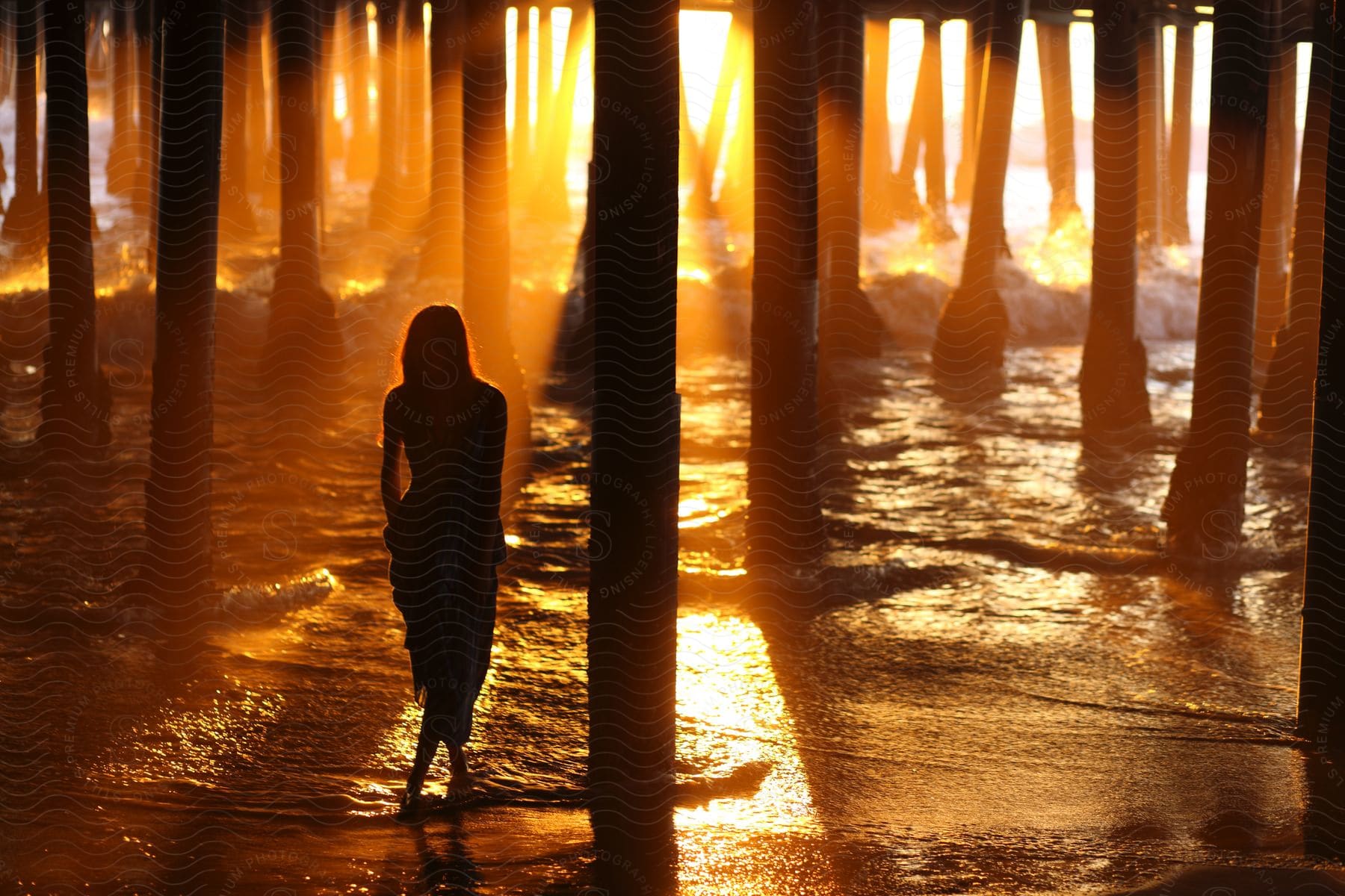 Female Standing Next To Wood Posts Under A Wooden Construction At The Beach