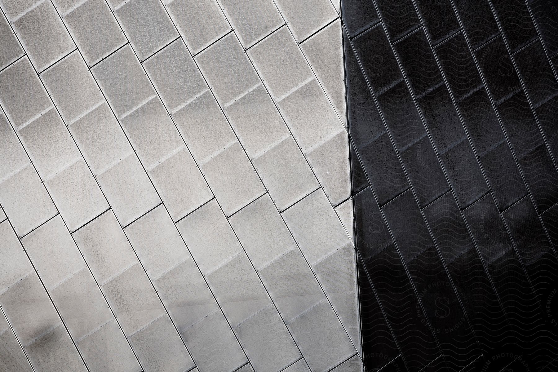 A gray brick in a white and black image showcasing an abstract pattern and texture of metallic tiles indoors