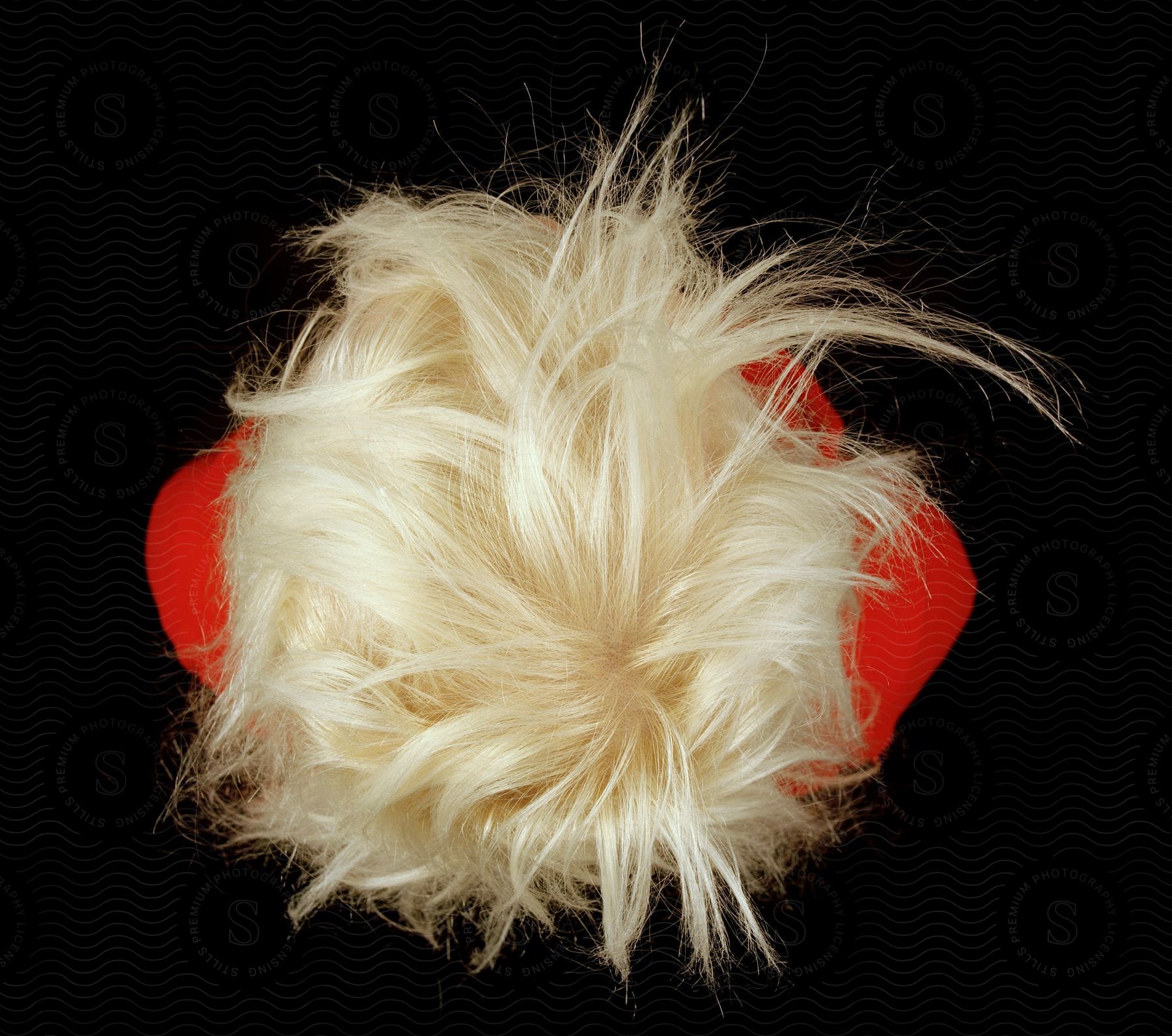 A blonde woman seen from above with messy hair in a studio setting