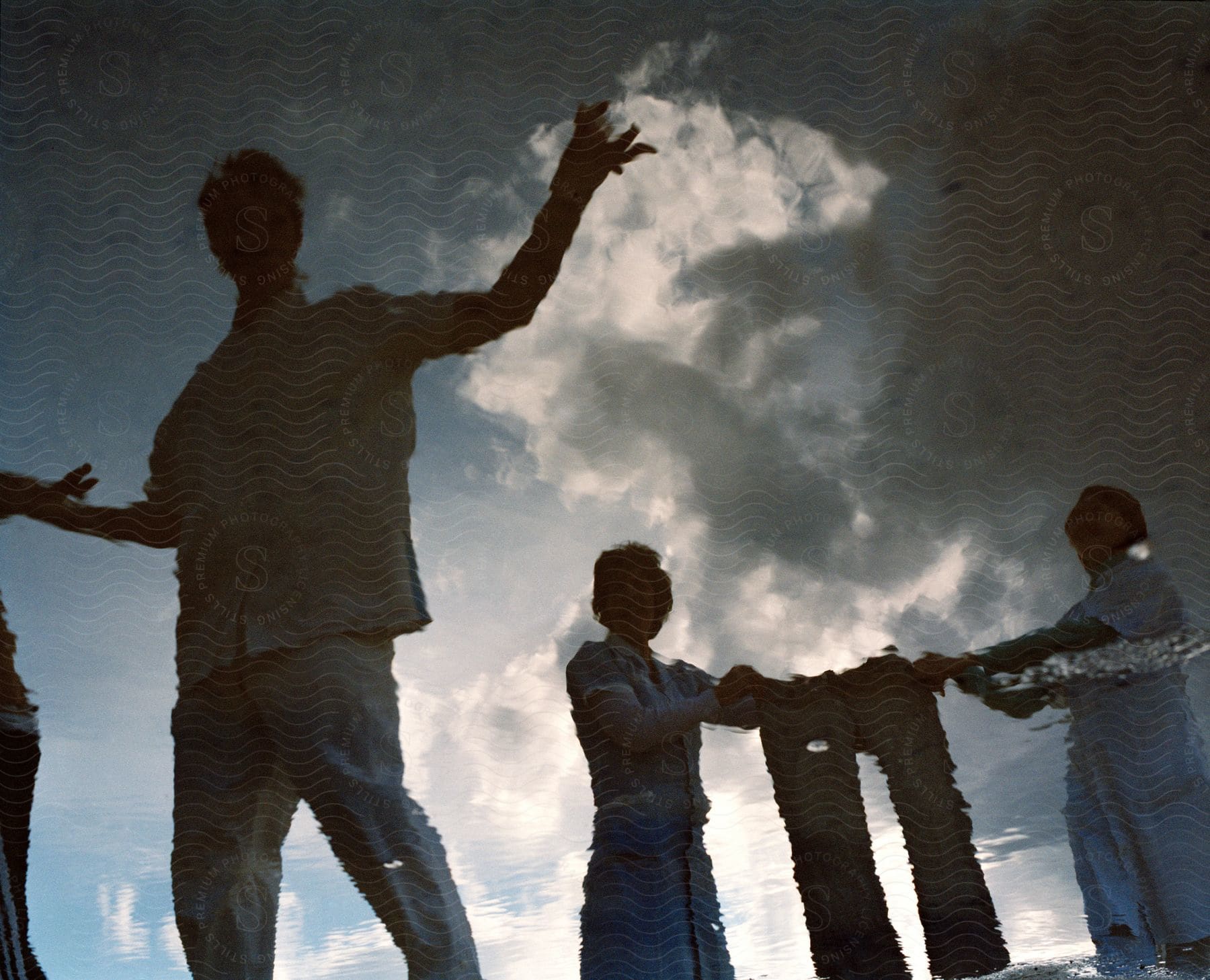 A group of people holding up and modeling pants outdoors