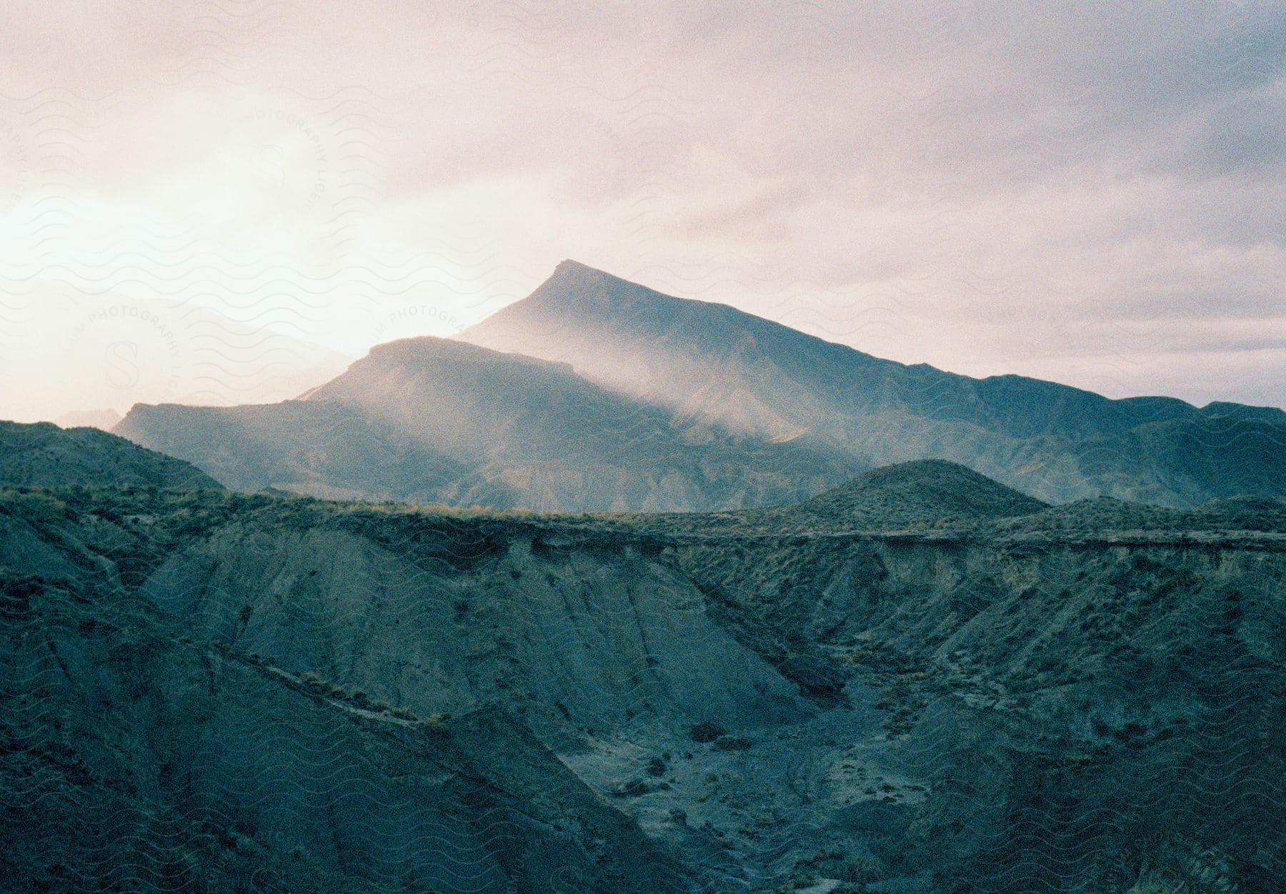 Natural landscape with mountains and hills next to a crater