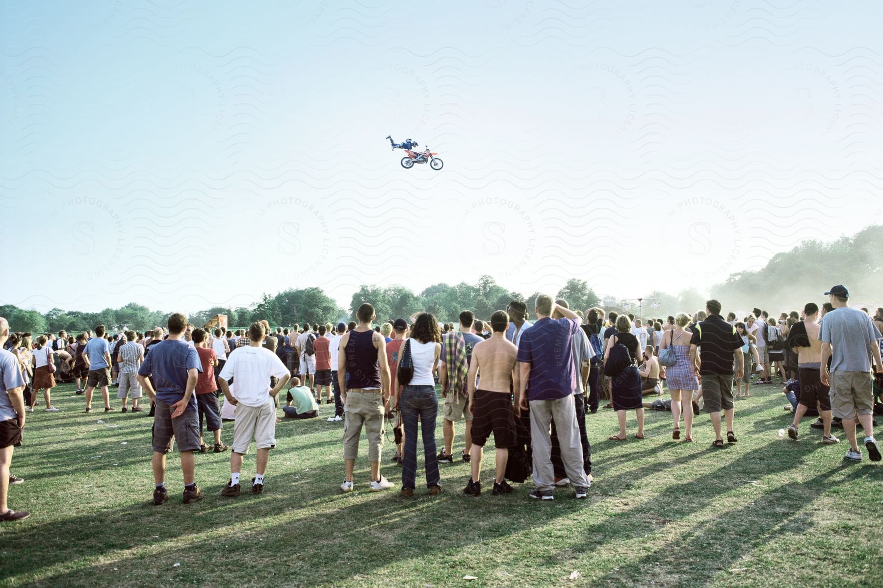 A person jumping a dirt bike in front of a large crowd