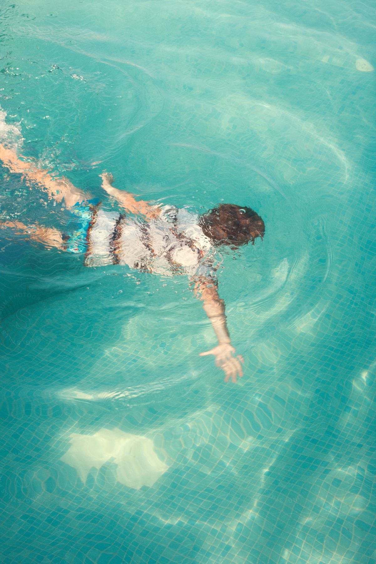 A boy swimming underwater in a pool in almirida crete enjoying the clear water and having fun