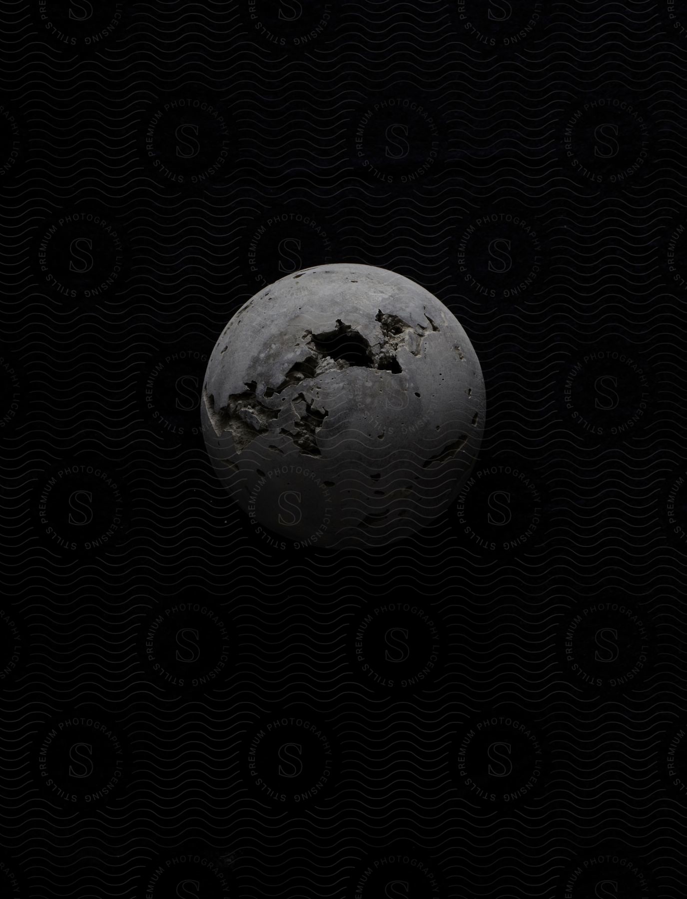 Black and white image of a geode sphere with crevasses against a black background