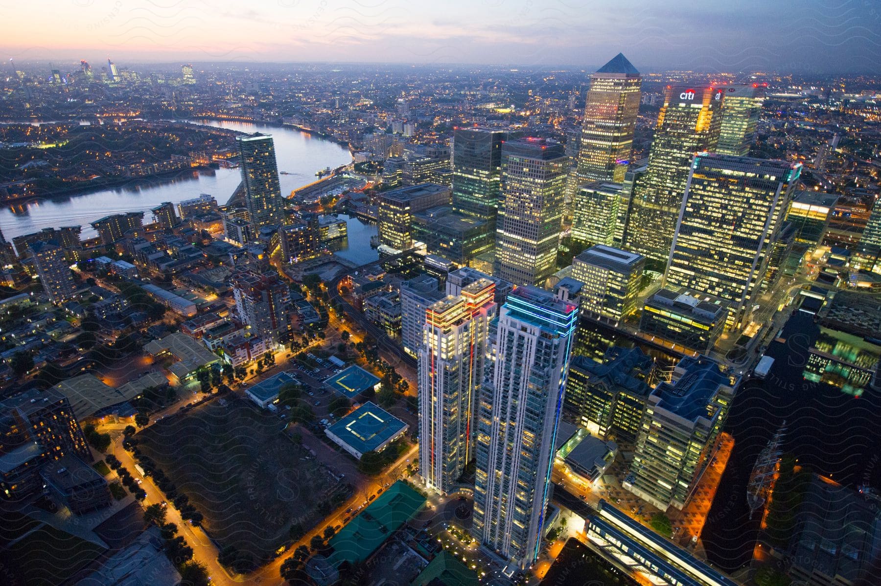 A modern city with tall and small buildings illuminated at dawn