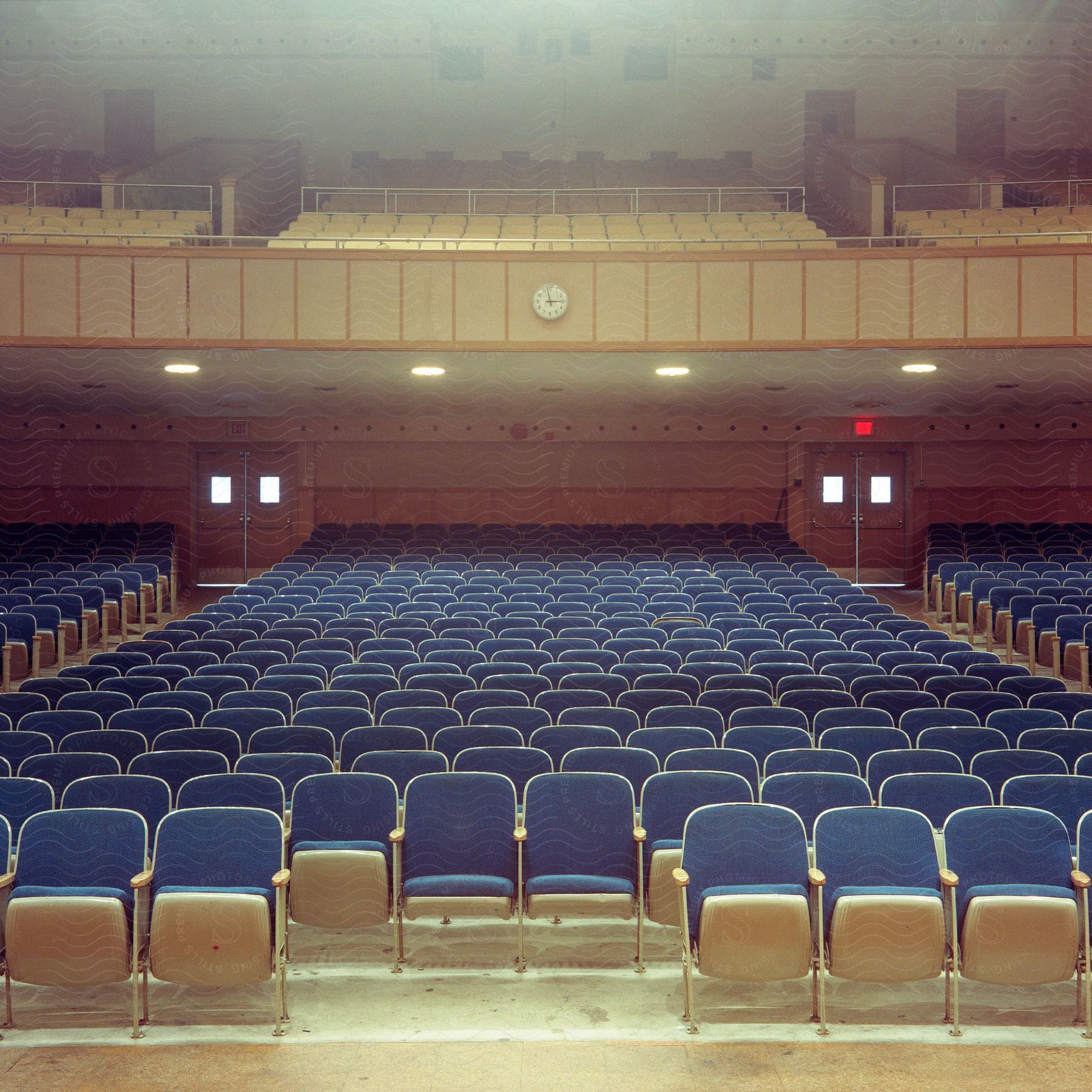 An auditorium with blue seats on the ground floor and yellow seats on the upper floor