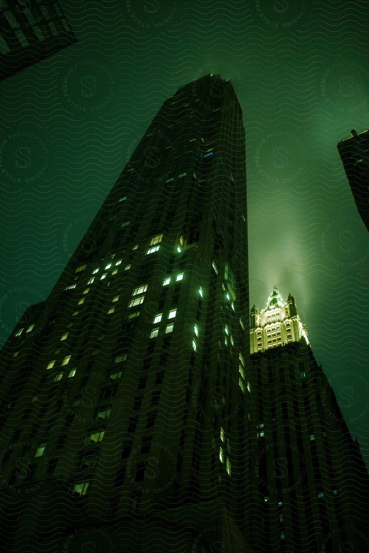 Tall dark skyscrapers under a green night sky in new york