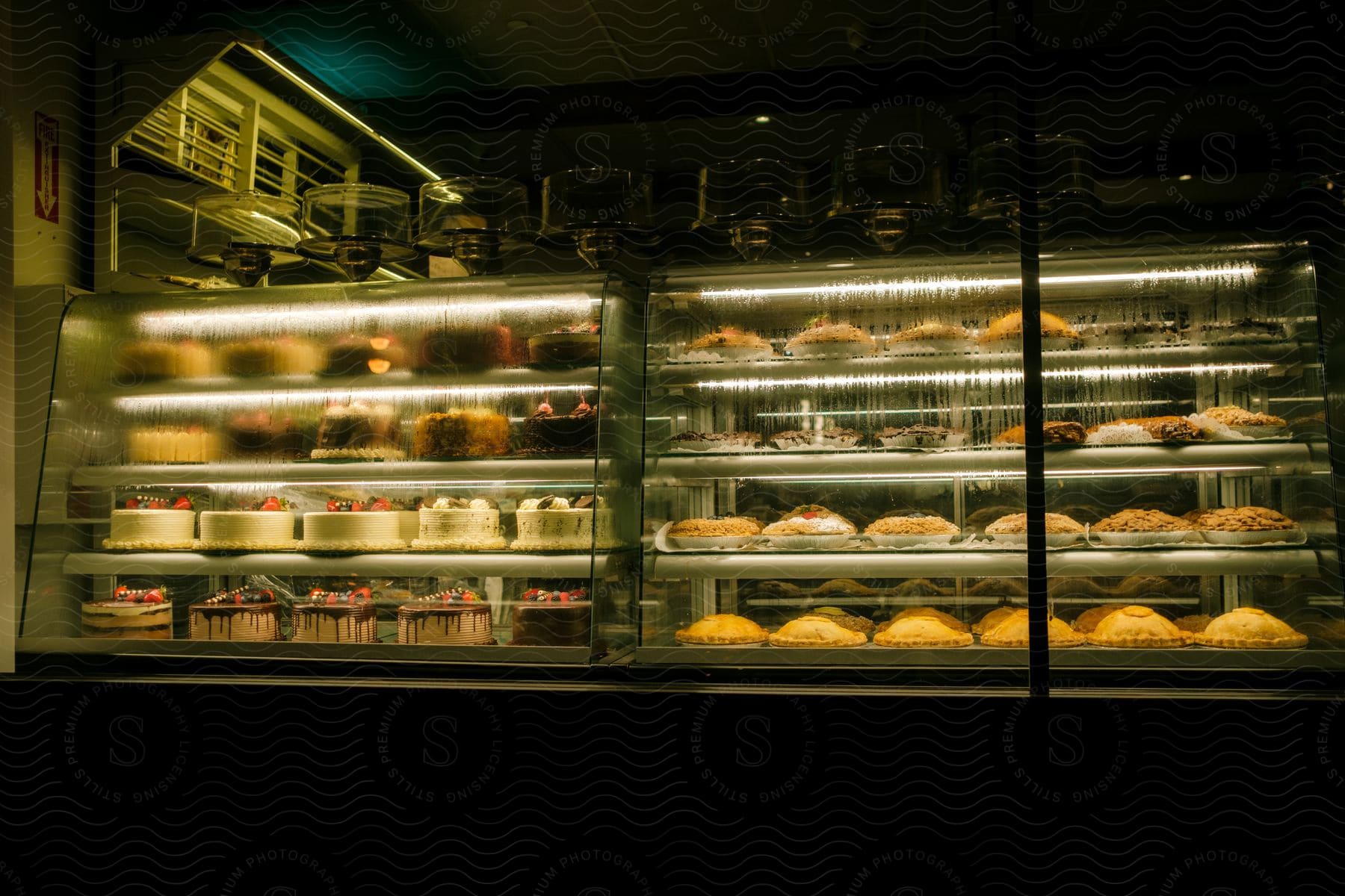 A bakery shop showcases cakes and pancakes in a fogged glass case creating a cozy ambiance